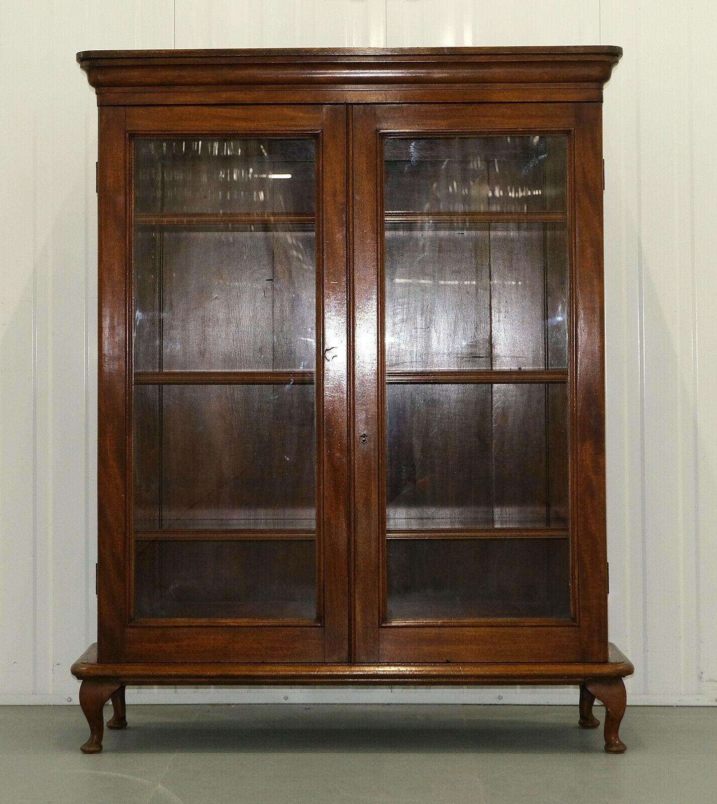 We are delighted to offer for sale this classic brown mahogany two doors bookcase on cabriole legs. 

This fine, elegant and practical bookcase/cabinet has a rich brown colour, standing on four cabriole legs. The solid adjustable shelves are ideal
