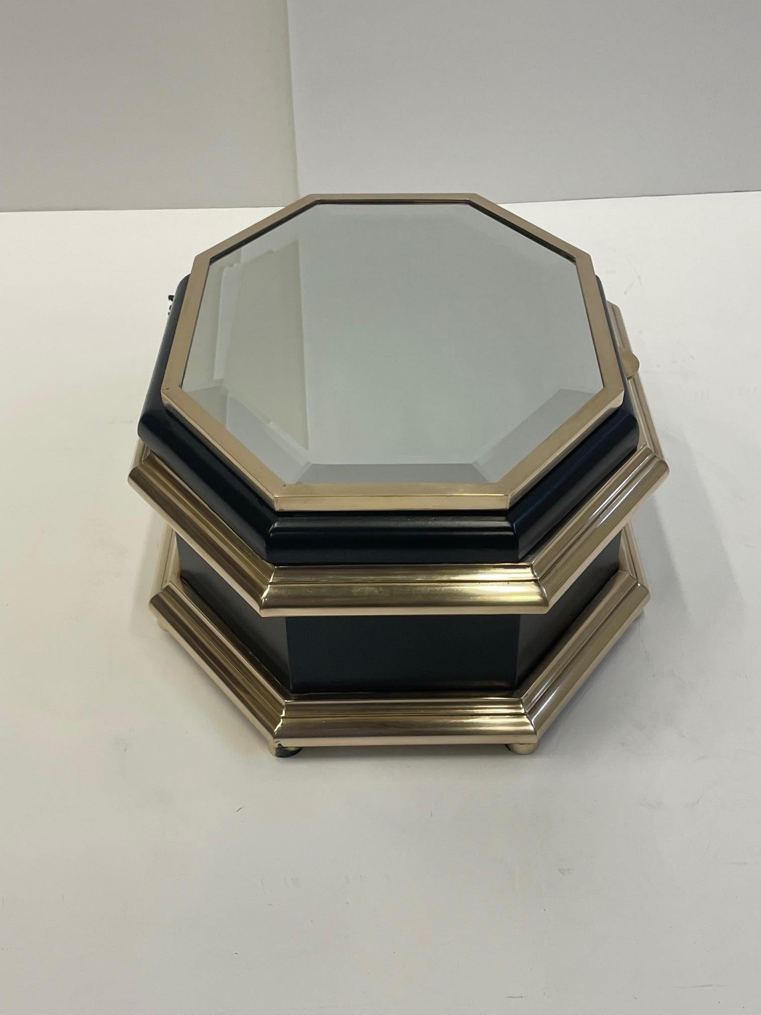 Sumptuous large black enamel box by Chapman having a marvelous interesting 8 sided oblong shape, mirrored top, brass decoration and plush velvet interior.