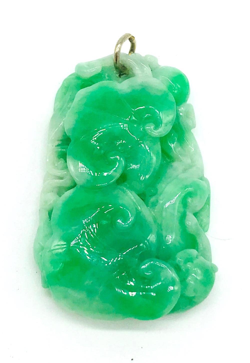 Rich Green Jadeite, Tiger Carving{Pendant with Floral and gold loop<br> Hidden tiger laying on side of carving is garnished In a bed of floral<br>79 grams in weight. Measures 1 x 1-3/4 long<br>GIA Gemologist inspected and evaluated