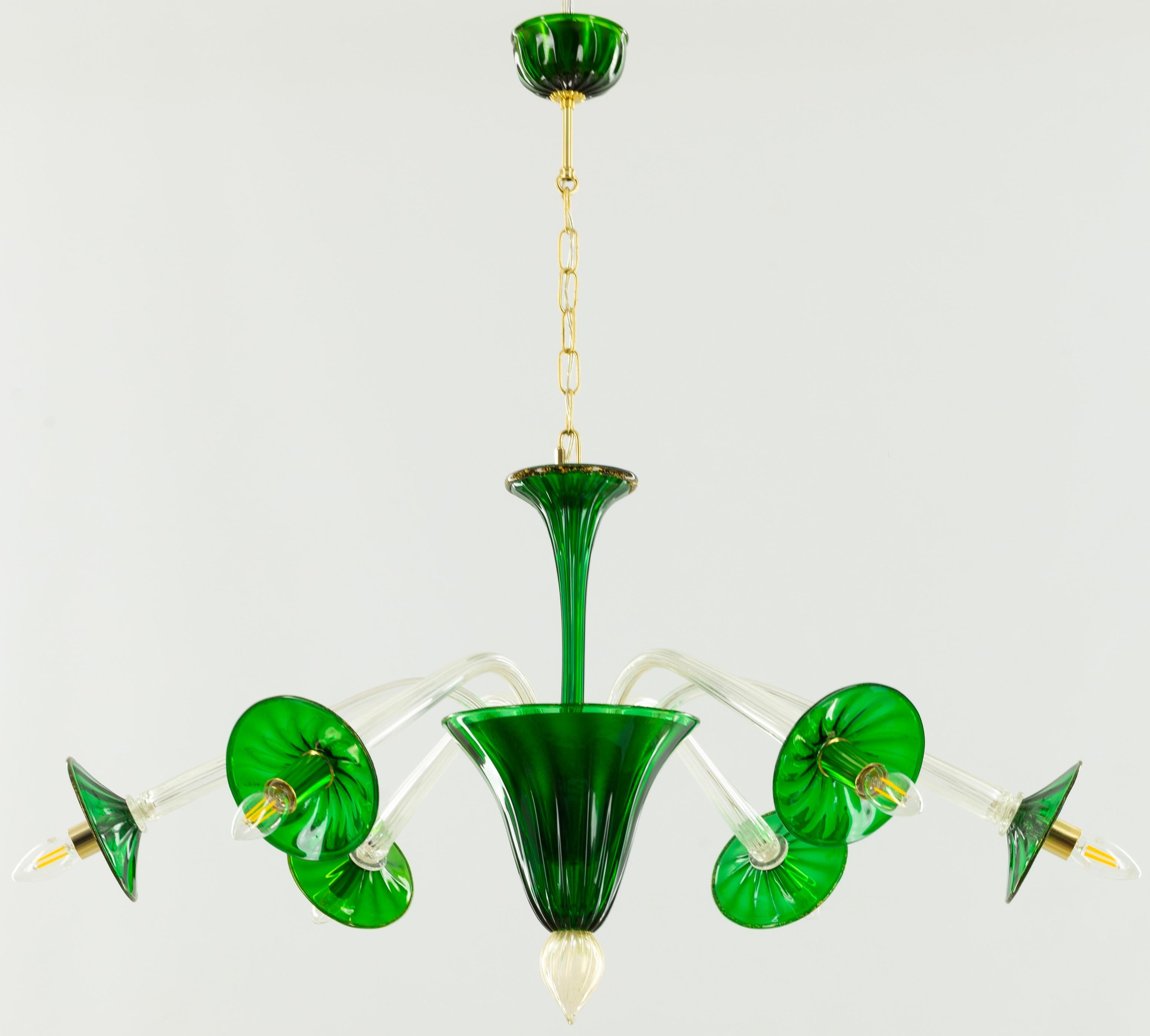 Questo accattivante lampadario in vetro di Murano, testimonianza dello squisito artigianato italiano, è caratterizzato da una vibrante tonalità verde smeraldo che attira l'attenzione. Il suo design elegante, caratterizzato da un corpo centrale a
