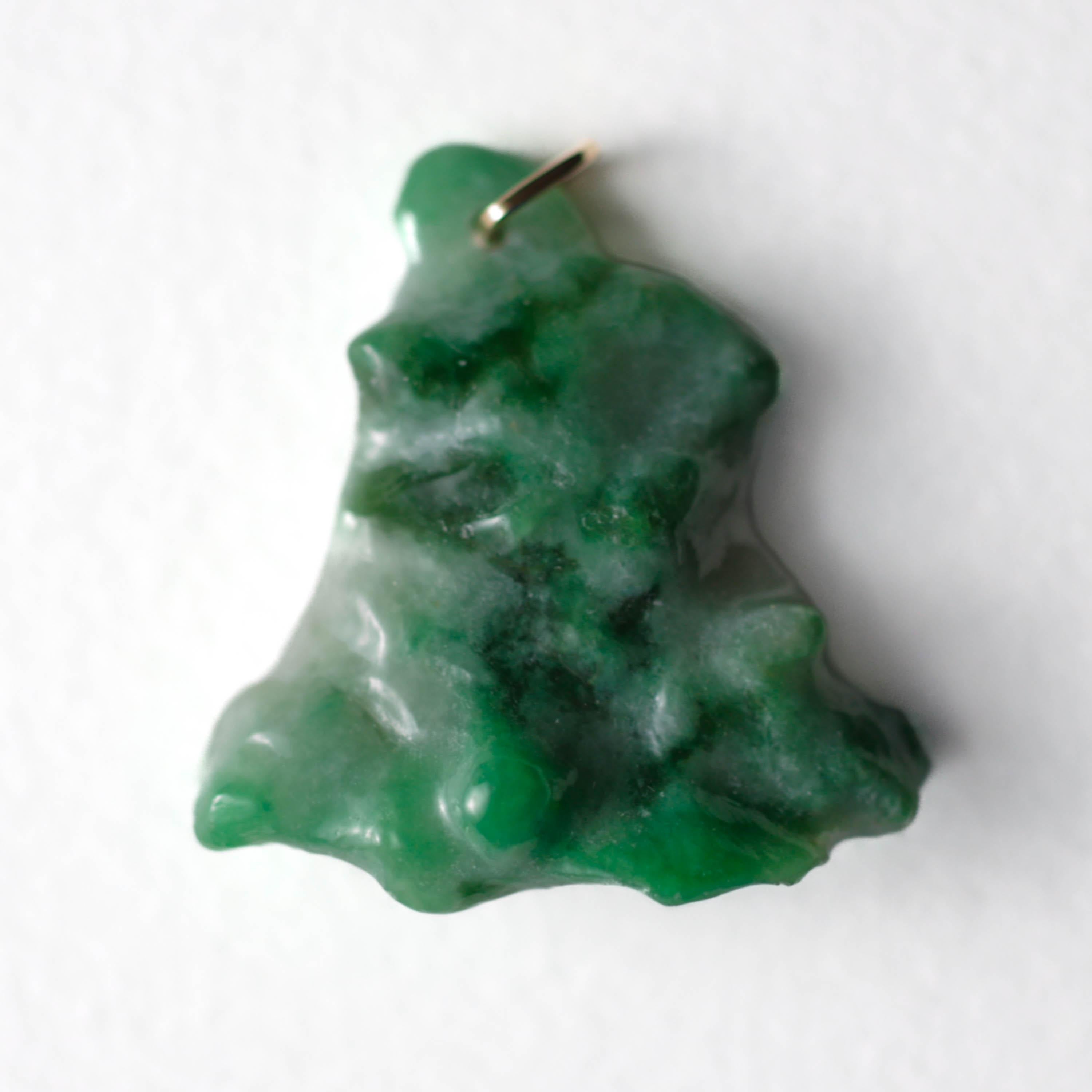 Dieser wunderschöne, smaragdgrün gesprenkelte, unbehandelte burmesische Jadeit-Jadestein wurde von Hand in eine dreieckige Form geschnitzt. Die Jade ist zwar undurchsichtig, aber auch sehr lichtdurchlässig, so dass sie unter allen Lichtverhältnissen