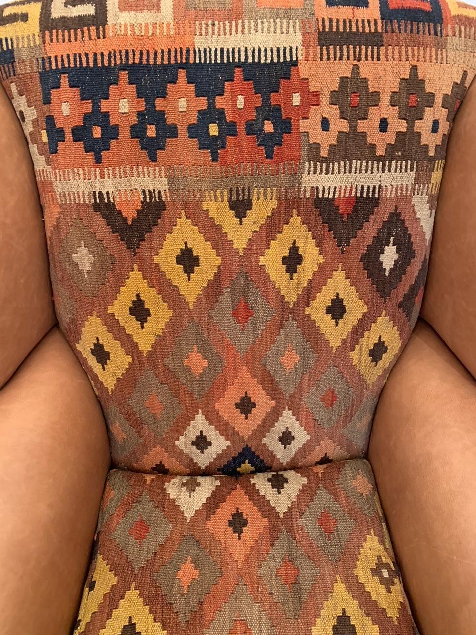 Handsome vintage wingback chair in new leather and vintage Kilim upholstery. The chair has mahogany legs and ball and claw feet.
Measures: Seat 22” D x 18.5” H.
  