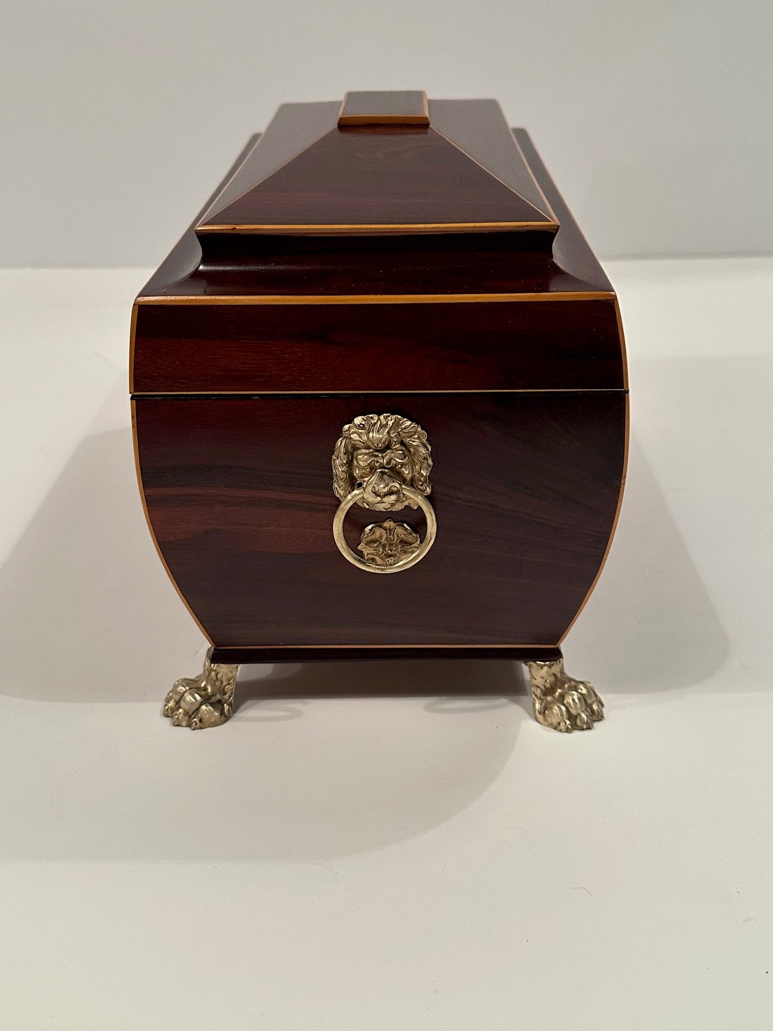 Sumptuous Regency style mahogany tea caddie having boxwood string inlay on the sides and handsome brass lion rings as well as paw feet.  Key included.