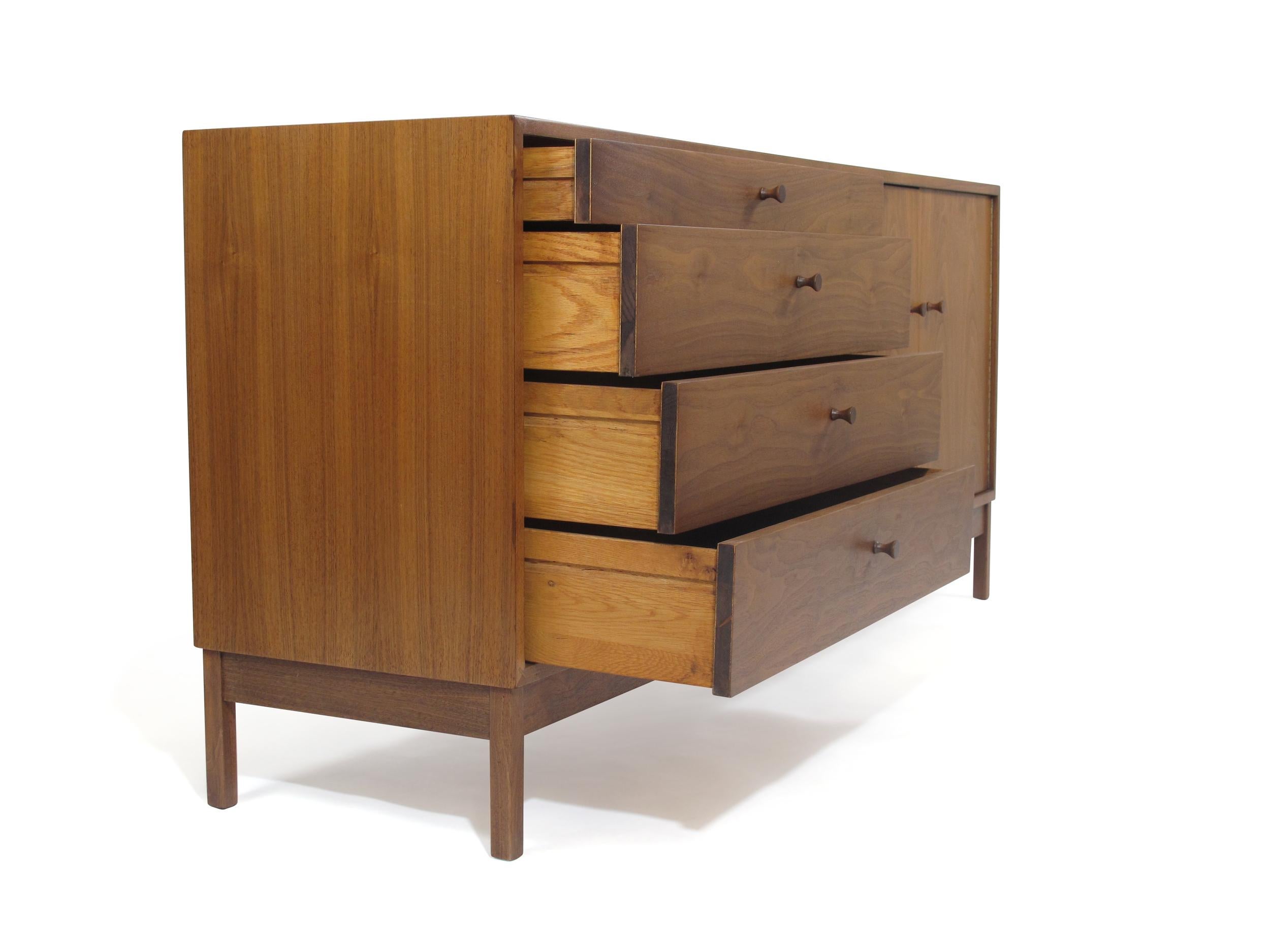Midcentury black walnut credenza cabinet designed by Richard Artschwager, circa 1953 United States. This cabinet is handcrafted of black walnut and features two pullout doors on rights opening to reveals and interior with an adjustable shelf, and