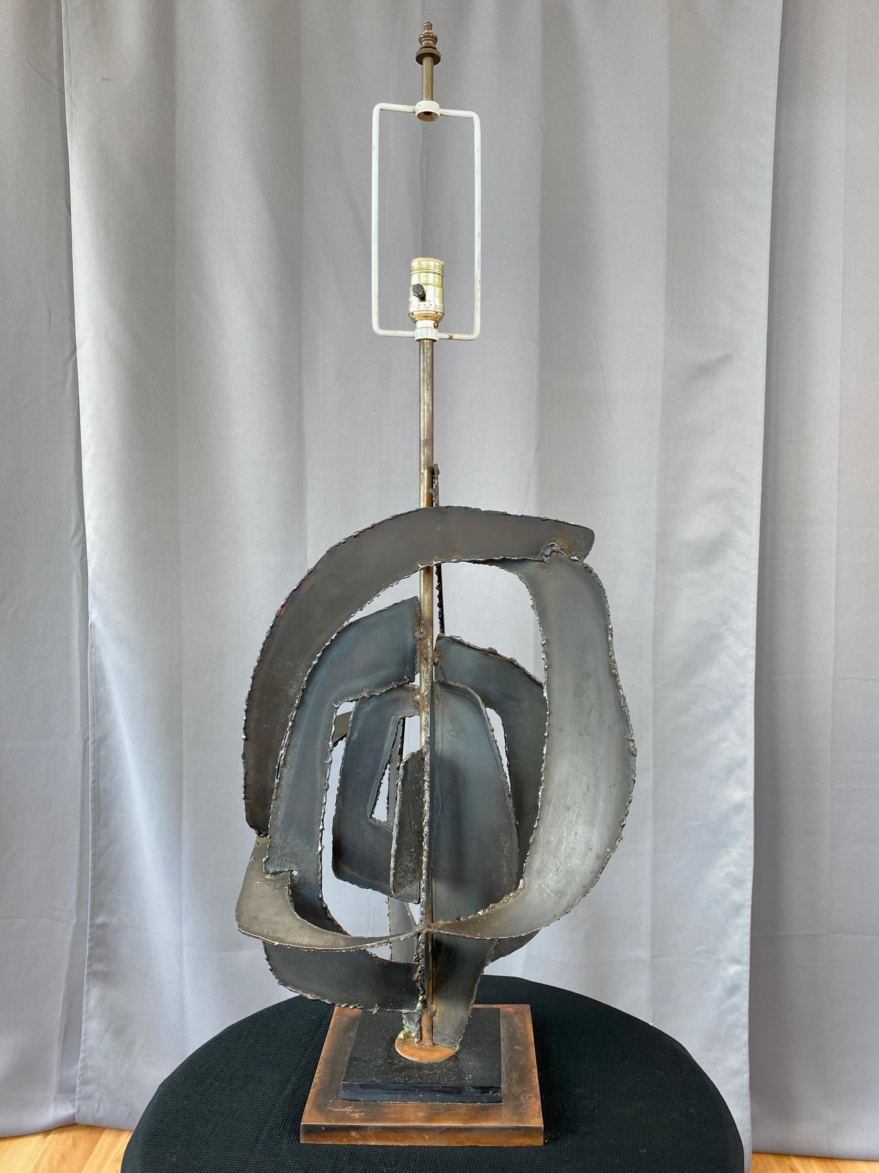 A very impressive early 1960s Brutalist steel and bronze finish table lamp from Richard Barr’s Studio Collection for Laurel Lamp.

Large and sculptural multiplanar body of torch cut steel plates with a dark finish described by Laurel Lamp as