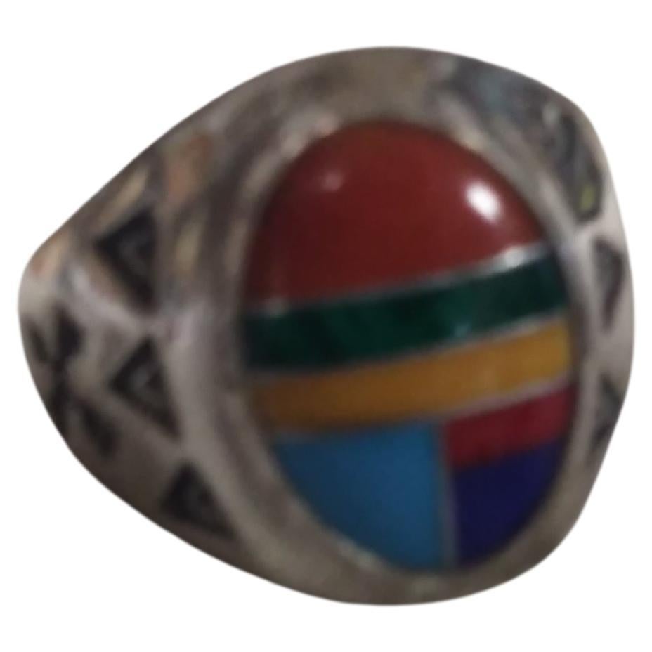 Richard Begay was a Navajo American that was born in Navajoland, Arizona. He was known for his jewelry creations. This ring is made of sterling silver with semi-precious stones. It was handcrafted by the artist.

The ring contains coral, lapis,