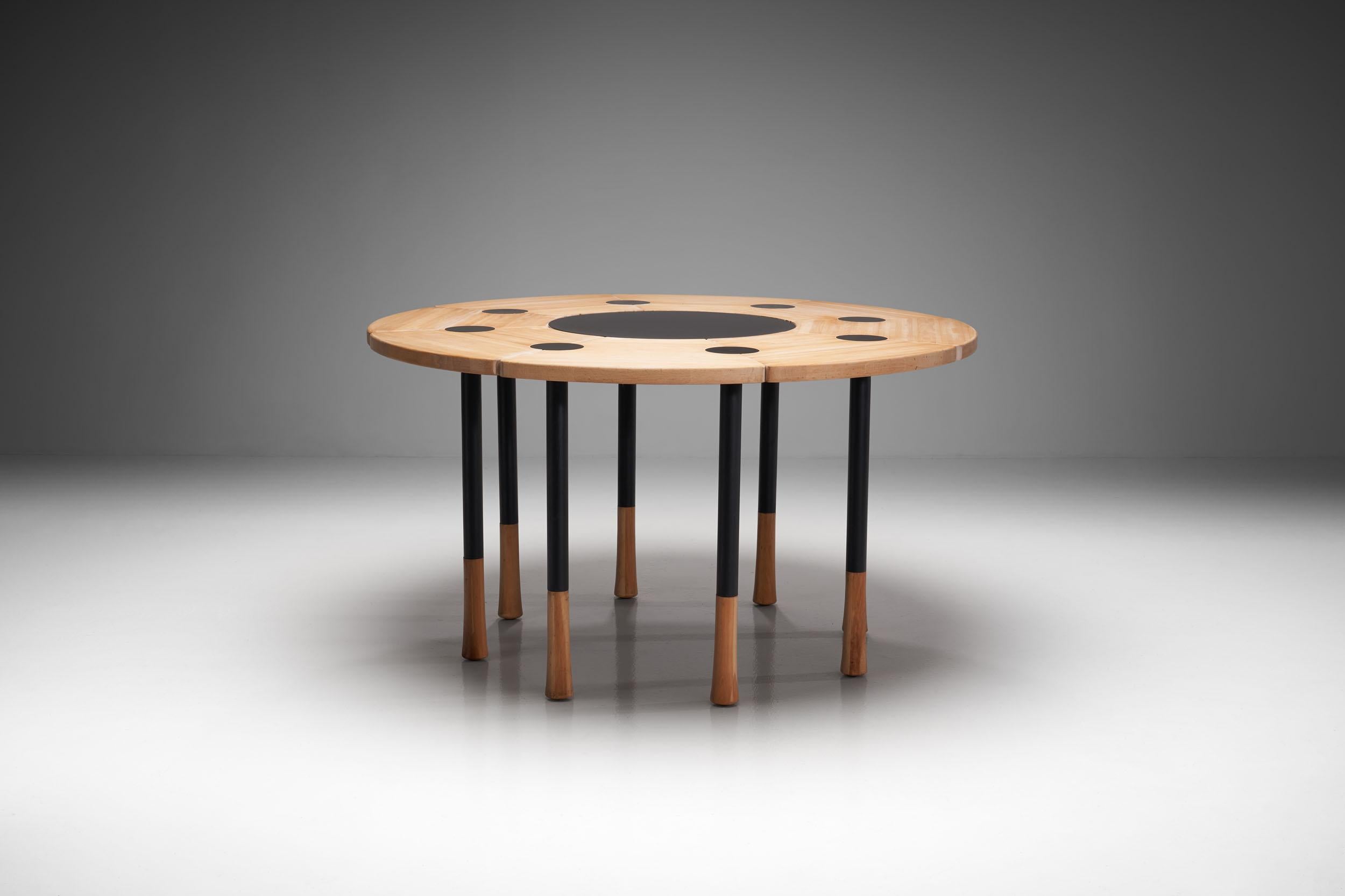 This extraordinary sculptural round dining table has strong lines and proportions and was made in very small numbers. 

The table consists of eight beech elements that have a petal like shape. The elements are connected with eight black metal round