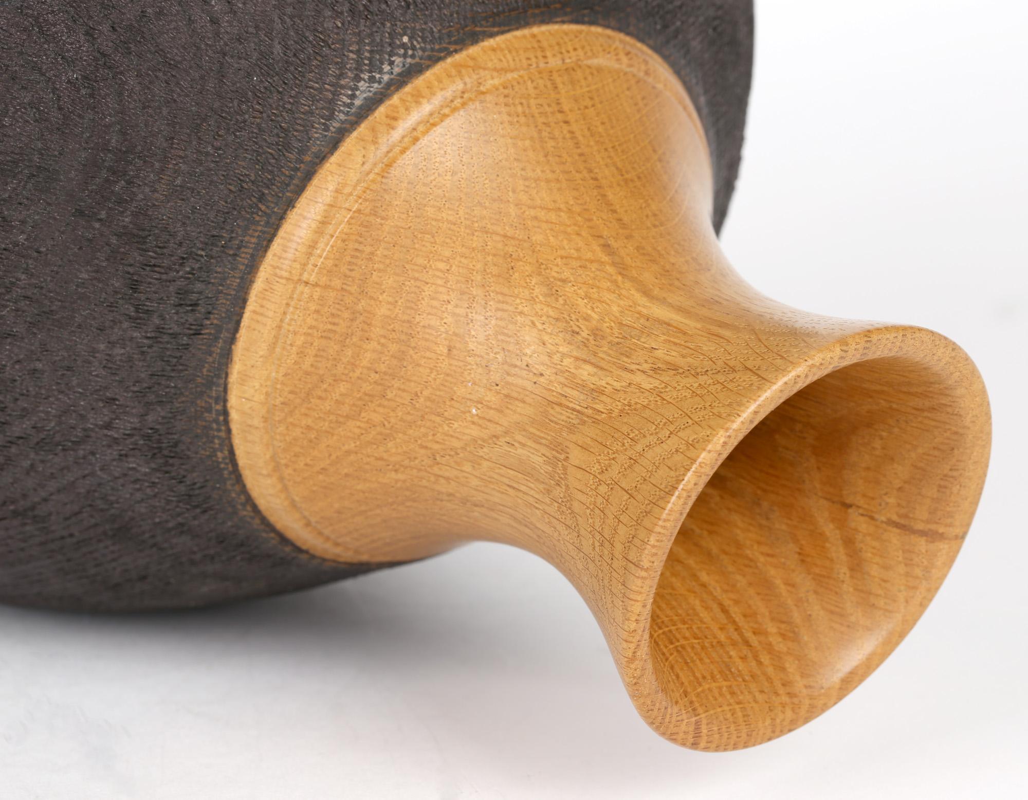 Un grand vase en bois de chêne tourné et sculpté, de fabrication anglaise, par Richard Chapman (né en 1951) et datant du 20e siècle. Le grand vase en forme de bouteille repose sur un pied étroit et arrondi, le corps de forme légèrement ovale avec