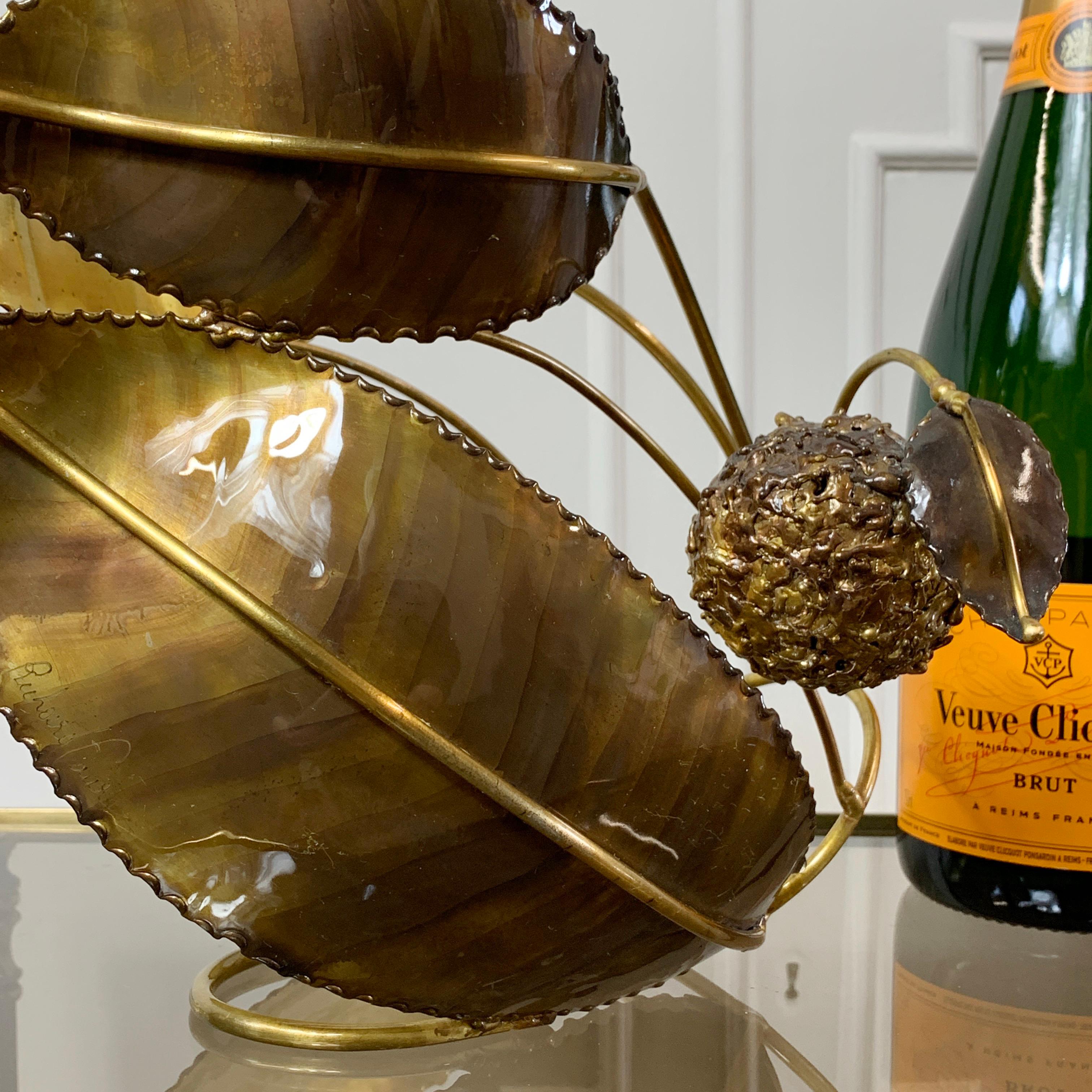 Un exceptionnel berceau à bouteilles de vin sculpté et signé par le célèbre artiste et sculpteur français Richard Faure.

Façonnée à la main en laiton, cette pièce rare et unique est entièrement signée et en superbe état. Elle présente des détails