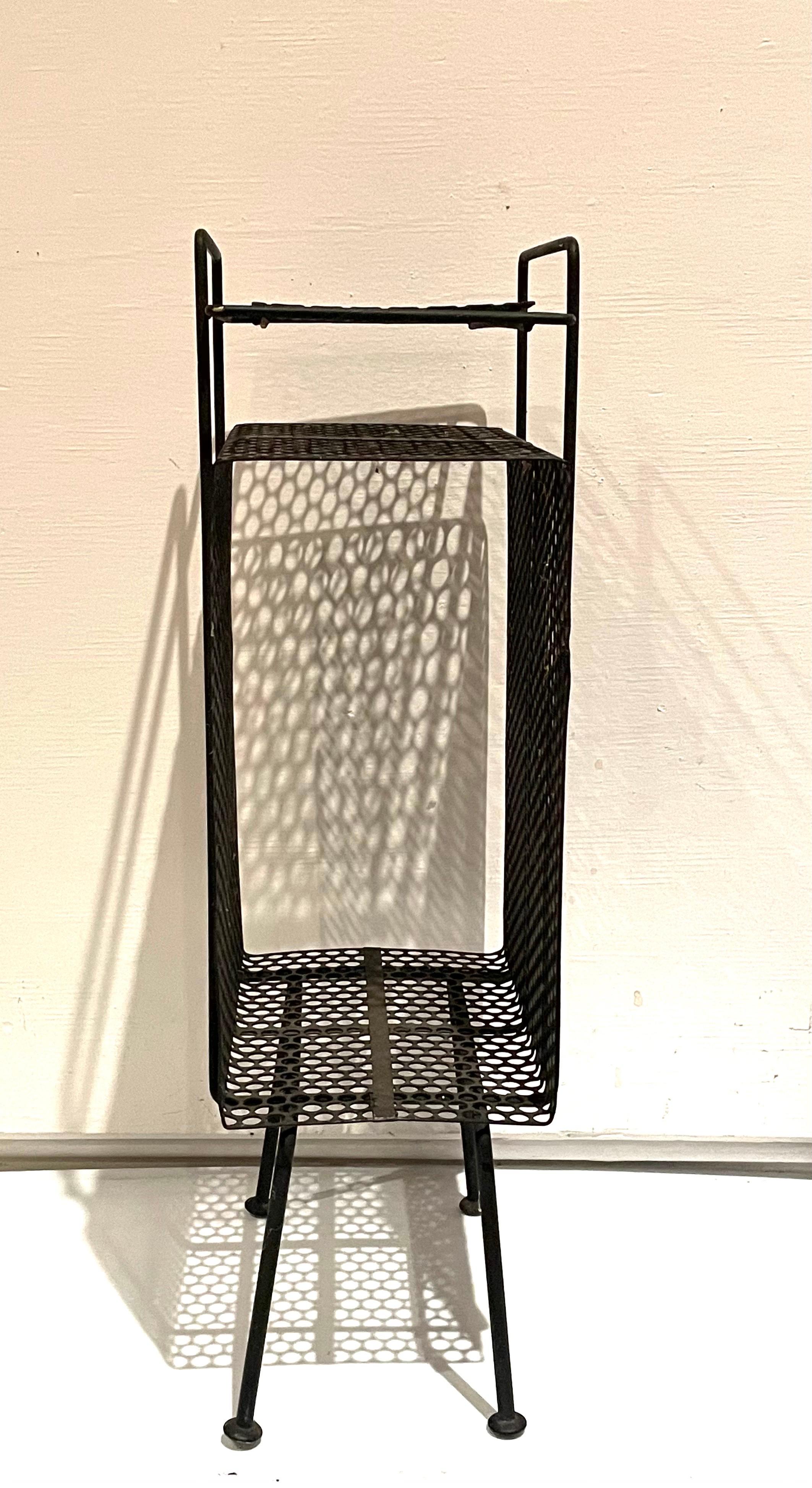 The 1950s Classic midcentury, atomic age era stand/rack original used for the telephone, phone directory, this one its in black finish with some wear light rust and patina due to age. Designed by Richard Galef for Ravenware.