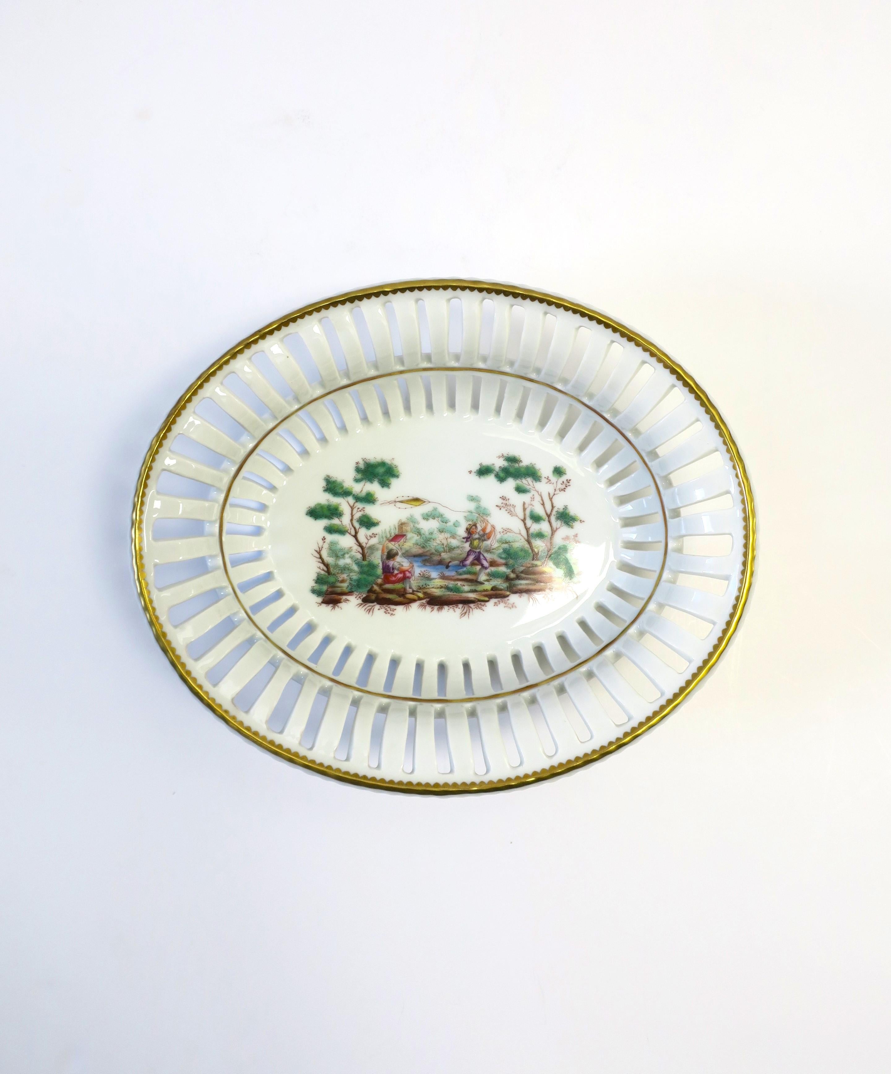 An Italian porcelain fruit or nut bowl by designer Richard Ginori, circa mid-20th century, Italy. Bowl is white porcelain, oval in shape, perforated, base scene of two boys playing with kites in countryside, edged in gold. With makers' mark on