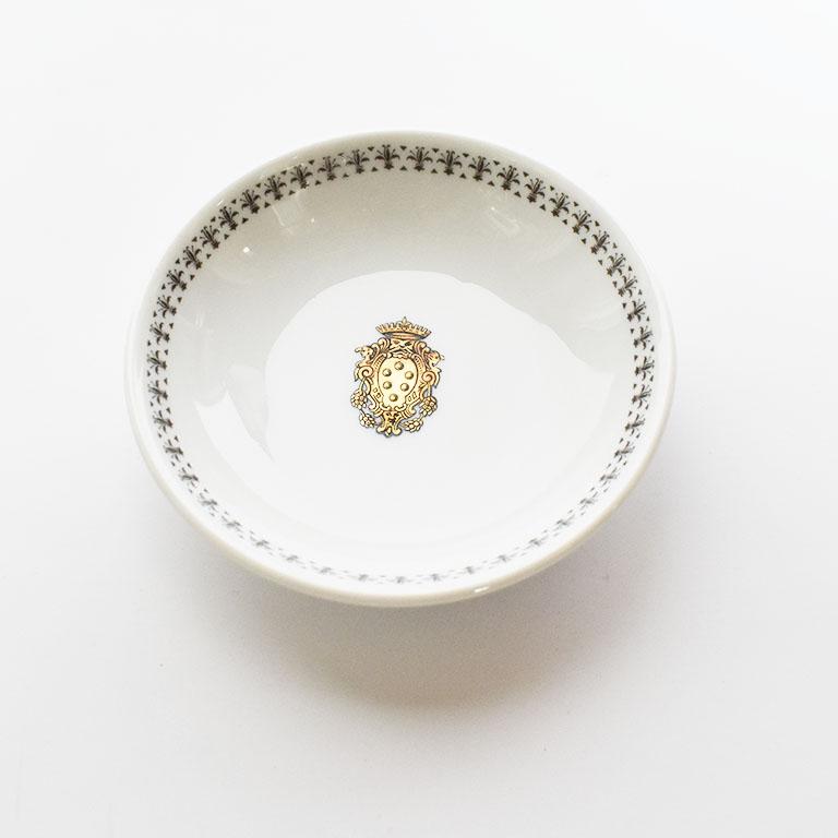 Beautiful circular porcelain dish by Richard Ginori. The lovely rare piece is round in form, with edges which curl up giving the piece a deep center. The exterior of the bowl is a crisp white porcelain. The interior of the dish is decorated with a