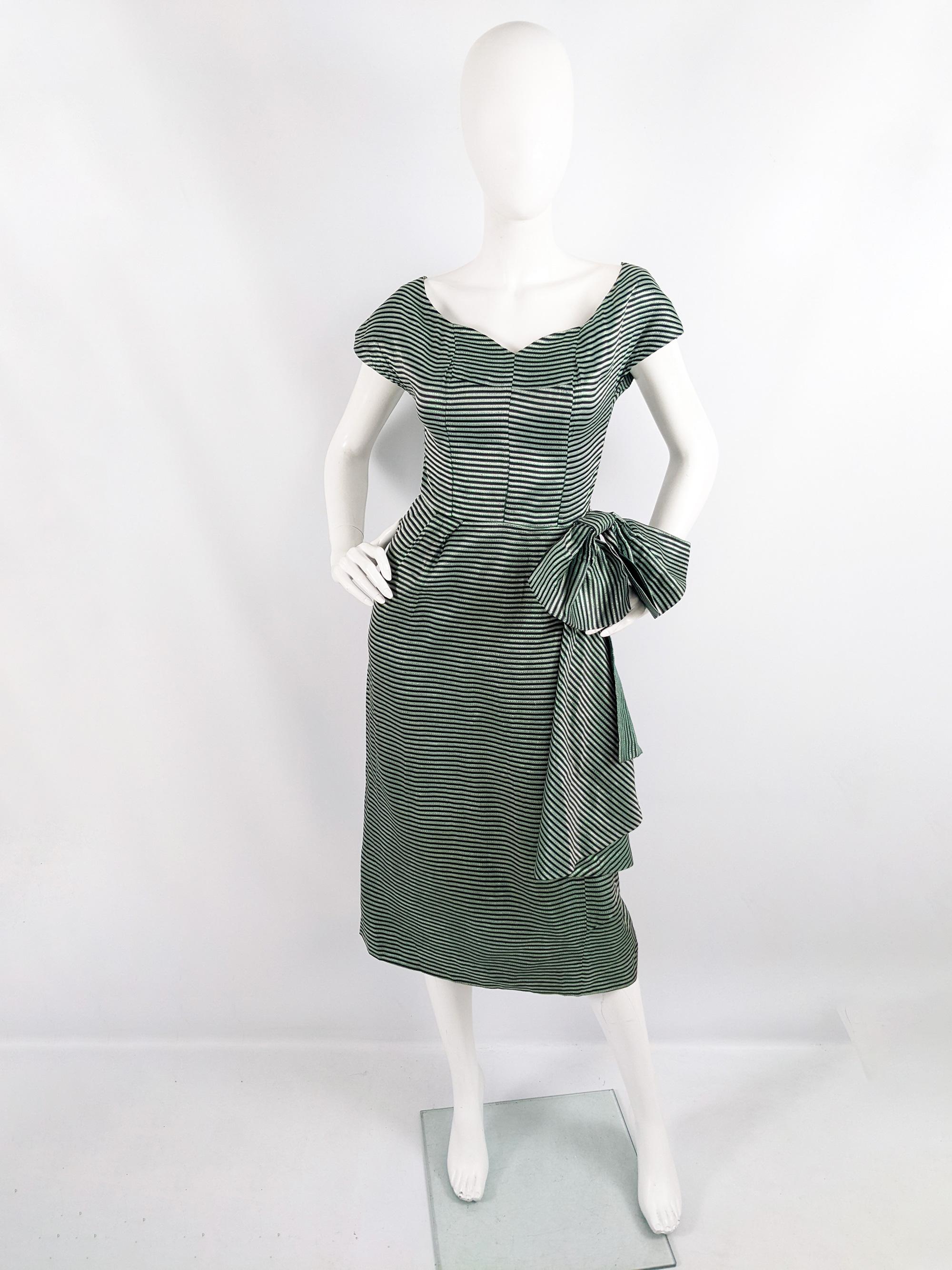 A fabulous vintage womens evening dress from the 50s by Richard Grossmark. In a green and black metallic lamé fabric with a huge bow on the side, cap sleeves and a flattering, sweetheart neckline.

Size: Marked vintage 36 but measures roughly like a