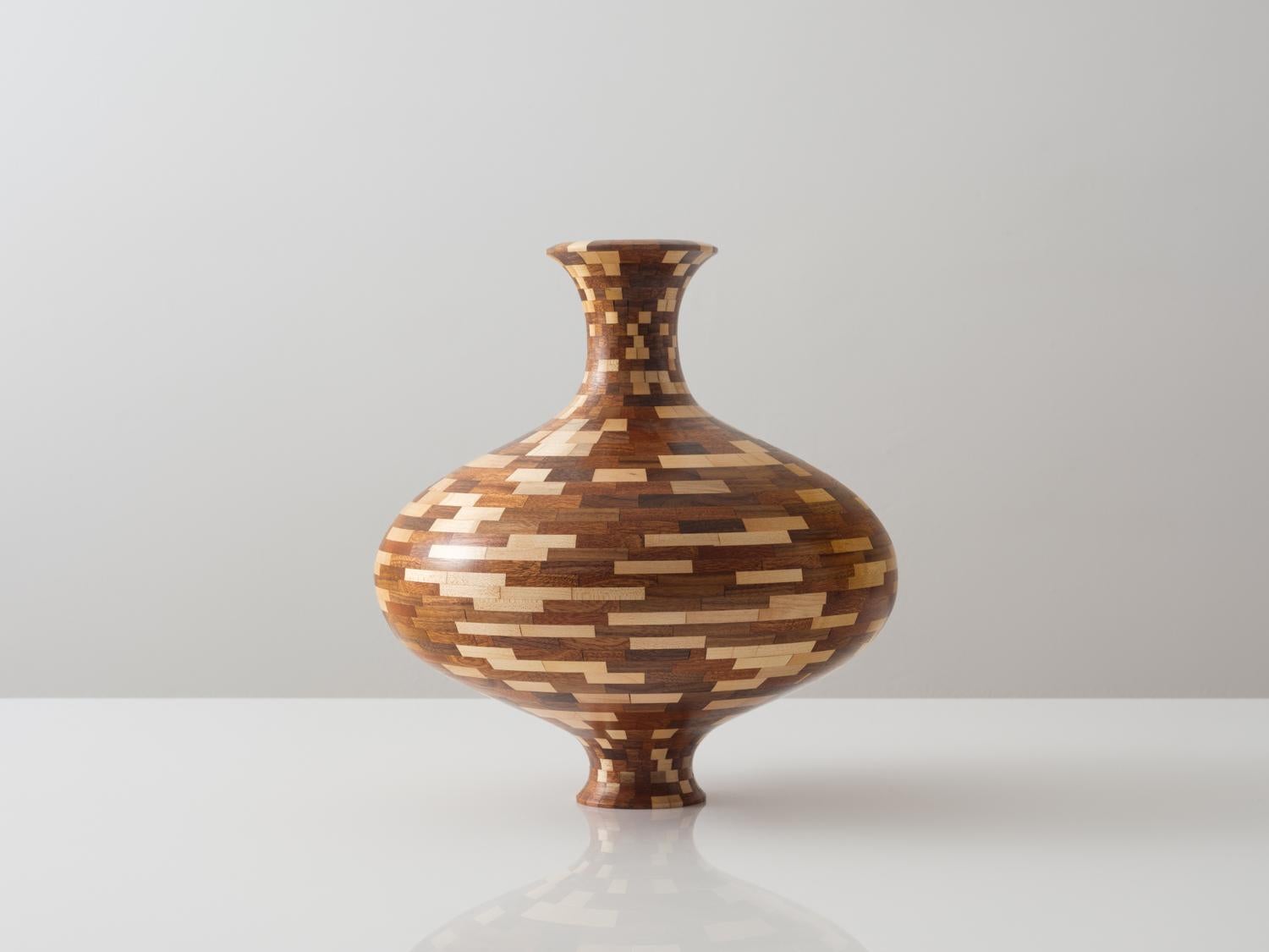 Questo vaso a forma di catena è realizzato con una miscela di noce, acero e mogano.

Questo pezzo, dalla forma discreta, è stato realizzato con una varietà di legni di recupero, ognuno con una colorazione e una venatura uniche. La forma