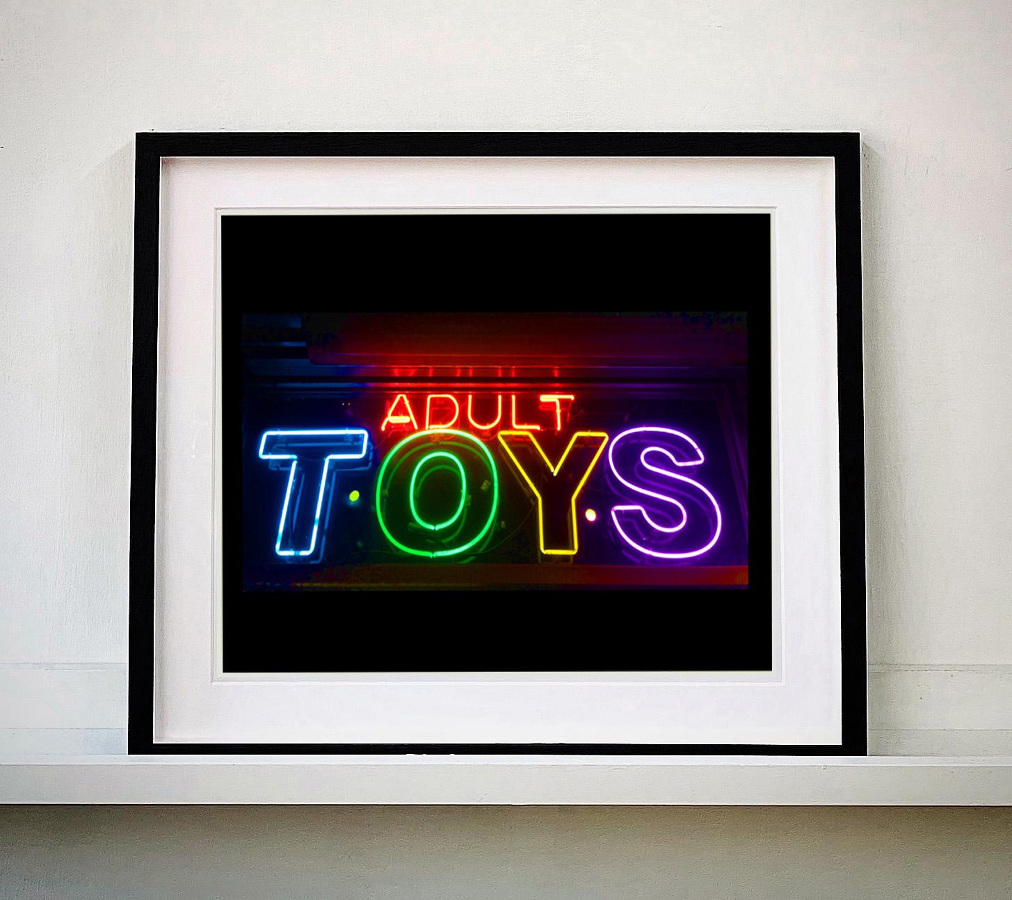Jouets pour adultes, néon des rues de New York.
Cette œuvre fait partie du portfolio de photographies de rue que Richard est en train de constituer et qui dépeignent la couleur, le tissu et la structure des villes avec un style distinct, alors