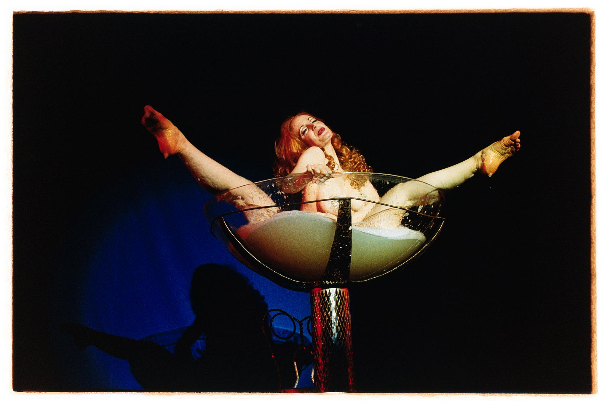 Catherine D'Lish, Tease-o-Rama, photograph capturing her champagne coupe Burlesque performance in Hollywood. Richard Heeps became well-known for his Burlesque photography as he captured performances in Britain & America. Spending a lot time with his