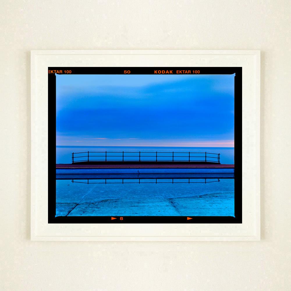 Craig y Don Pool, looking across the bay of Llandudno, Wales in the United Kingdom. Dreamy symmetry in shades of blue mesmerise your eyes in this photograph by Richard Heeps.

This artwork is a limited edition of 25 gloss photographic print from