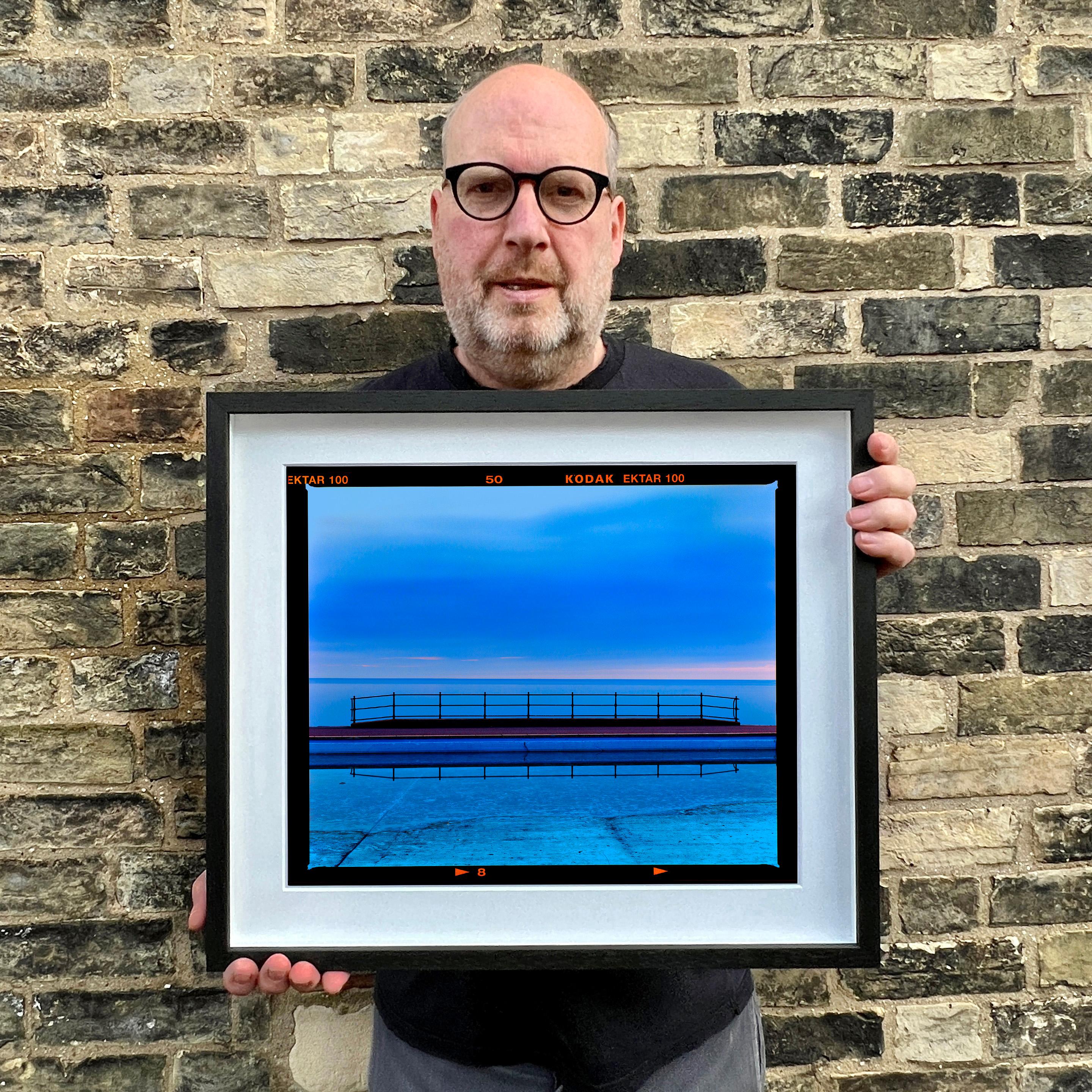 Craig y Don Pool, mirando a través de la bahía de Llandudno, Gales, en el Reino Unido. Una simetría de ensueño en tonos azules hipnotiza tus ojos en esta fotografía de Richard Heeps.

Esta obra de arte es una edición limitada de 25 copias