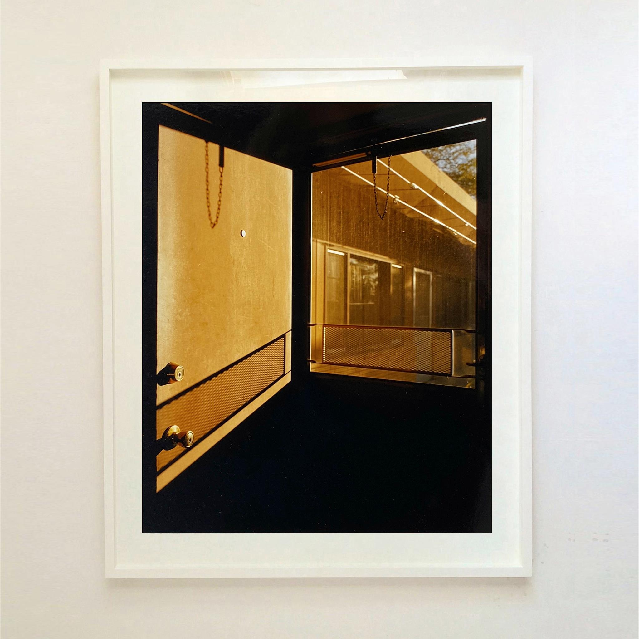 Puerta - Motel Lariat, Nevada - Fotografía cinematográfica en color - Print Negro de Richard Heeps