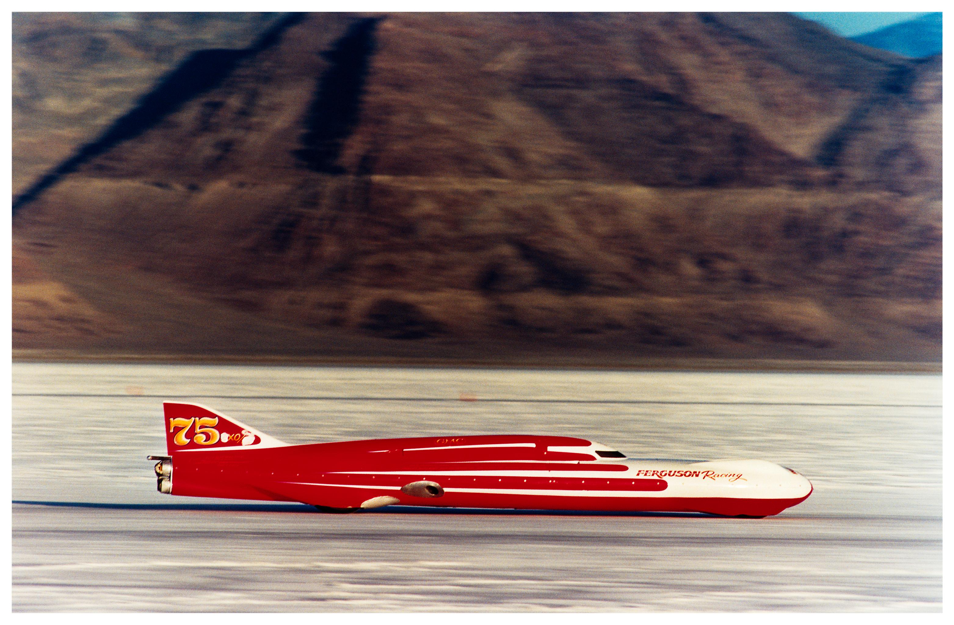 Ferguson Racing Streamliner, photograph taken in the iconic home of speed, Bonneville Salt Flats, just as the mountains contrast with the flat salt lake, Richard Heeps captured this racing car at high speed contrasting with the still effect of the