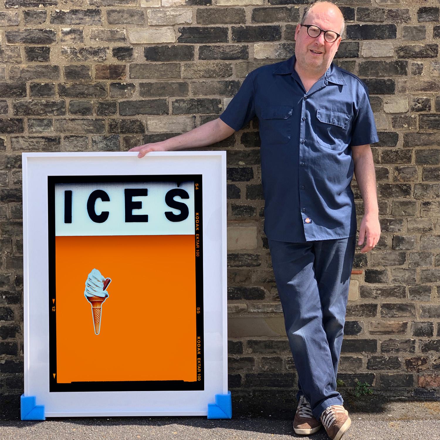 ICES, by Richard Heeps, photographed at the British Seaside at the end of summer 2020. This artwork is about evoking memories of the simple joy of days by the beach. The mustard yellow color blocking, typography and the surreal twist of the