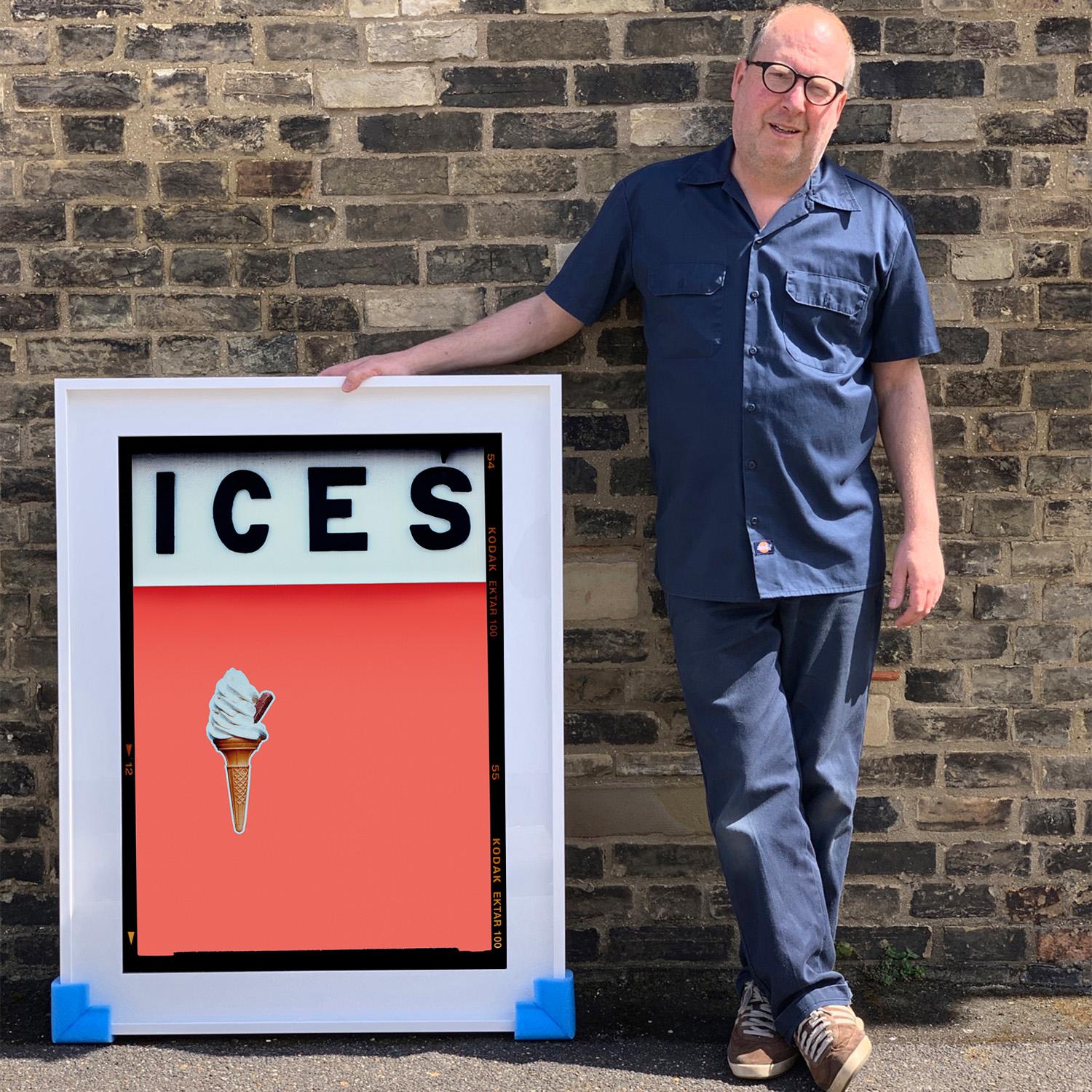 ICES, by Richard Heeps, photographed at the British Seaside at the end of summer 2020. This artwork is about evoking memories of the simple joy of days by the beach. The coral orange Melondrama color blocking, typography and the surreal twist of the
