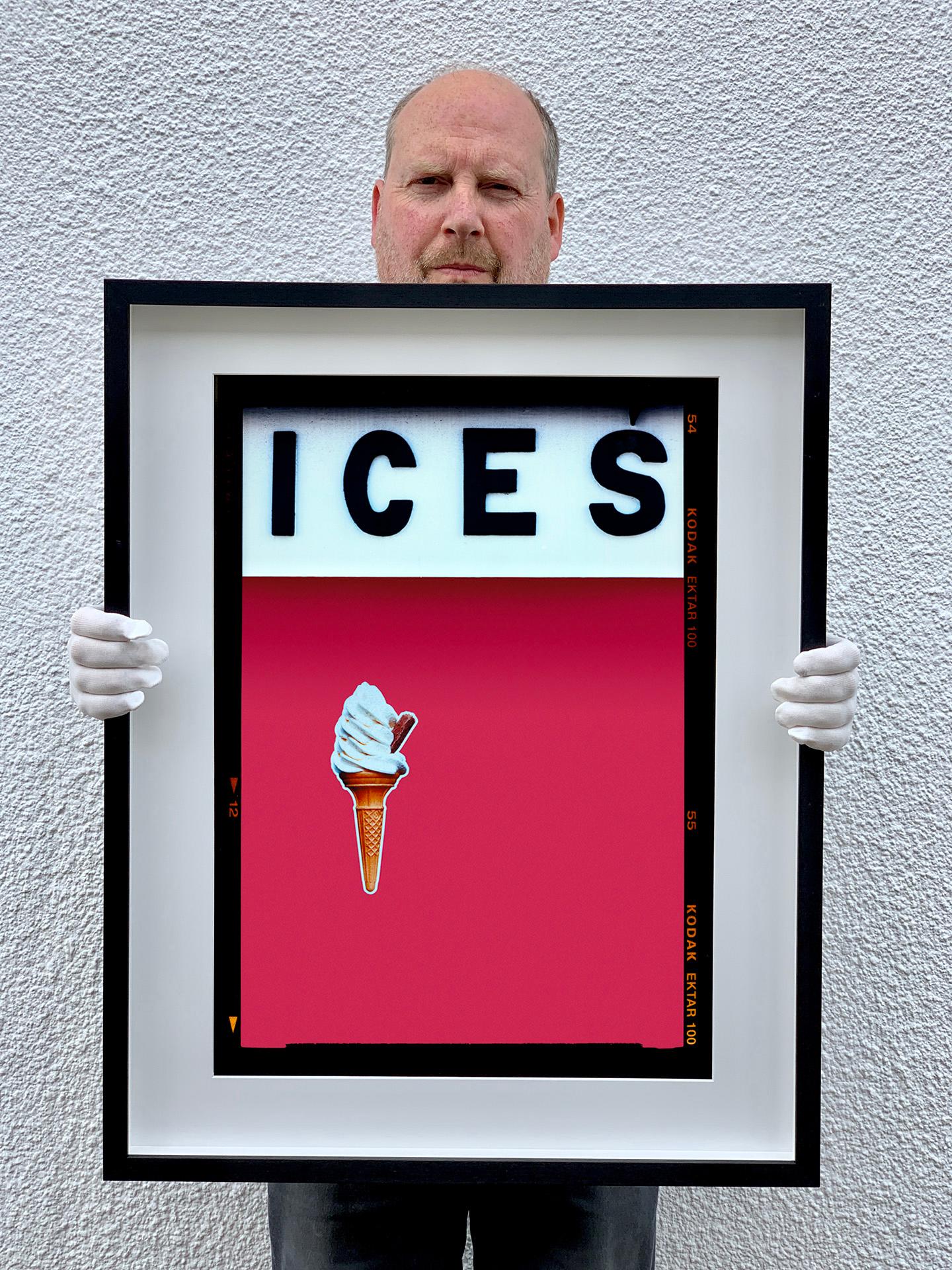 ICES, by Richard Heeps, photographed at the British Seaside at the end of summer 2020. This artwork is about evoking memories of the simple joy of days by the beach. The raspberry red pink color blocking, typography and the surreal twist of the