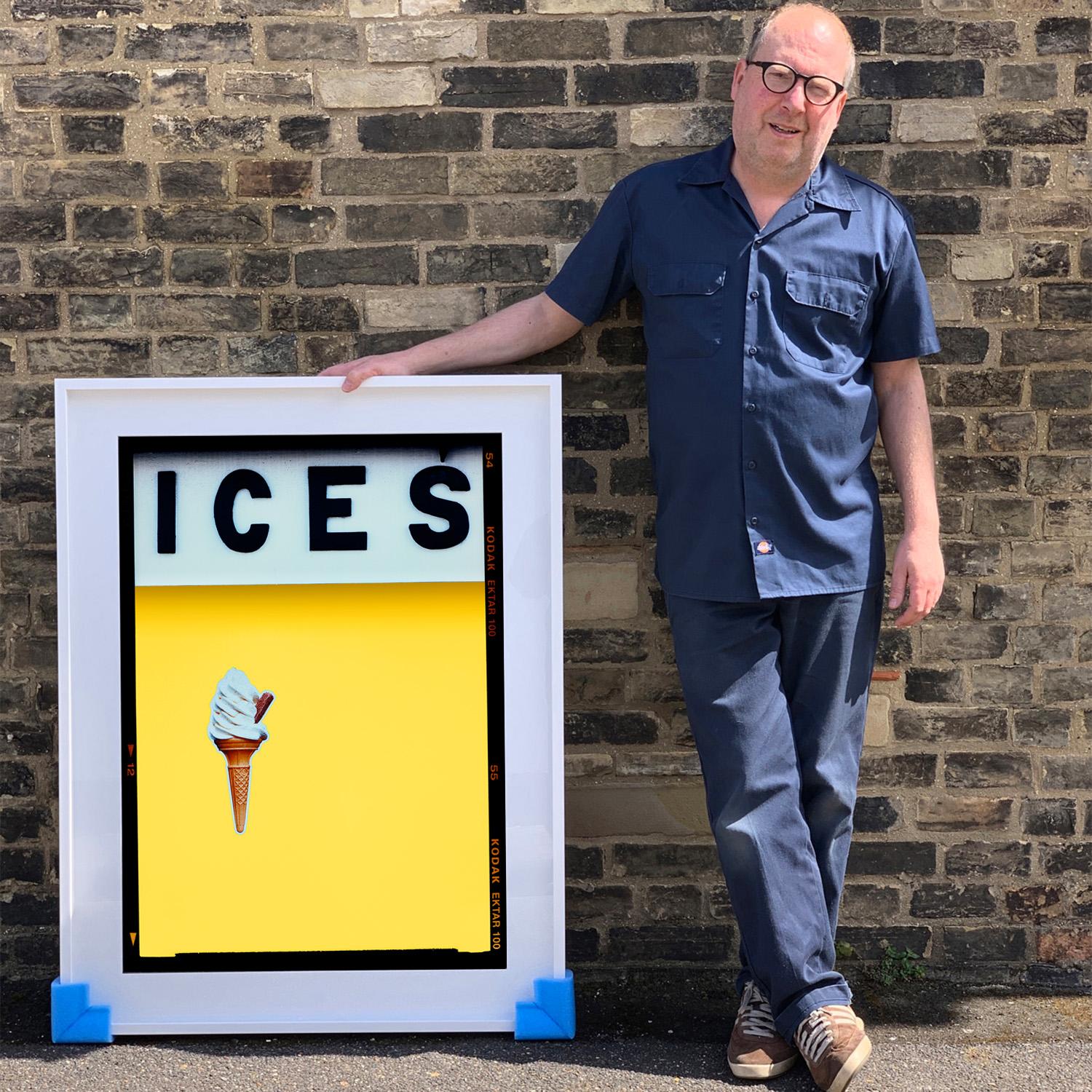 ICES, by Richard Heeps, photographed at the British Seaside at the end of summer 2020. This artwork is about evoking memories of the simple joy of days by the beach. The sherbet yellow color blocking, typography and the surreal twist of the