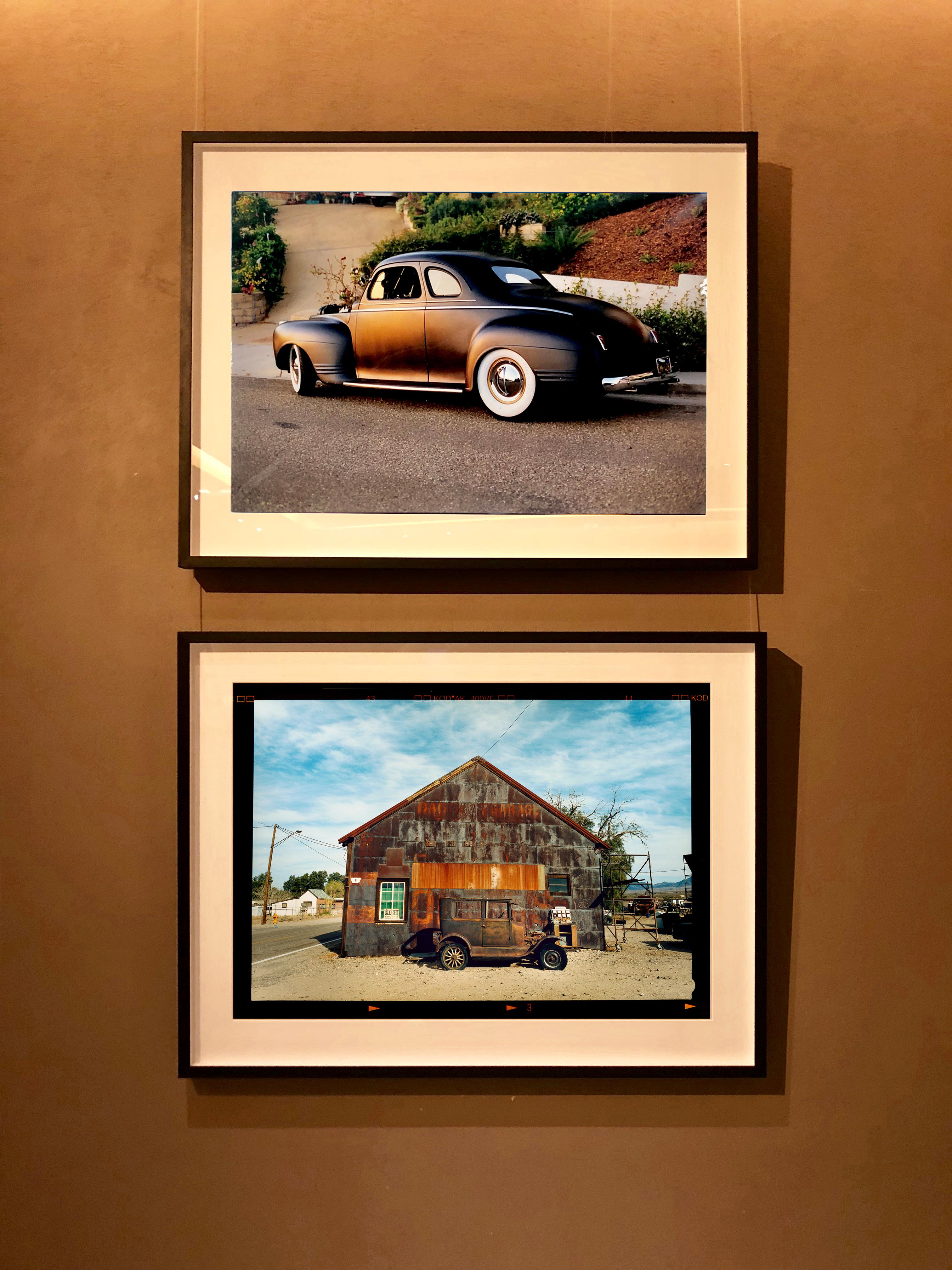 Modell T und Garage, Daggett, Kalifornien – Farbfotografie (Grau), Landscape Photograph, von Richard Heeps