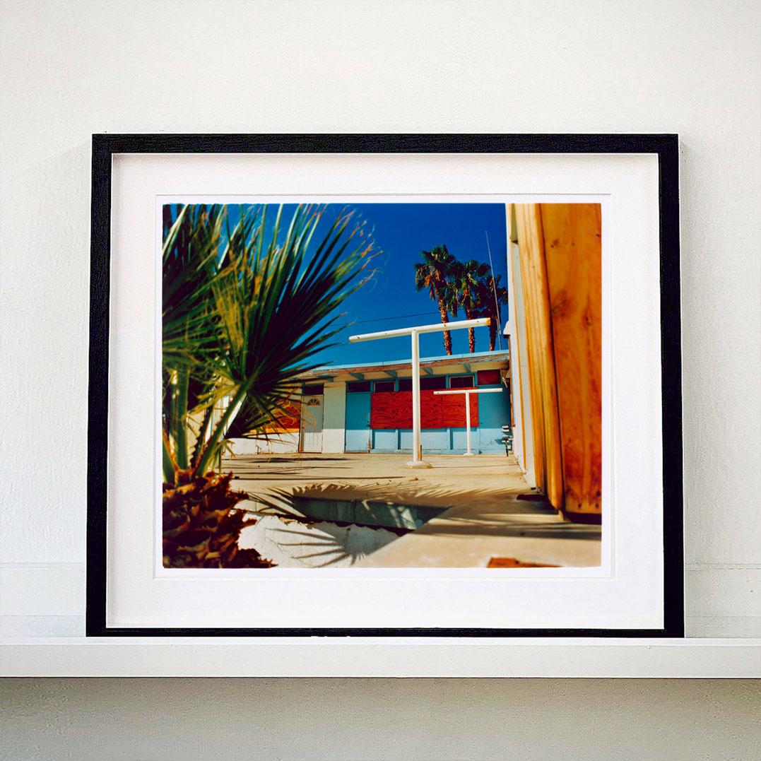 Motel Desert Shores, photographie tirée de la série Salton Sea de Richard Heeps. Cette œuvre d'art a l'allure d'un road trip en Californie du Sud, les couleurs sont si séduisantes, les palmiers créent une oasis dans le désert au milieu d'une