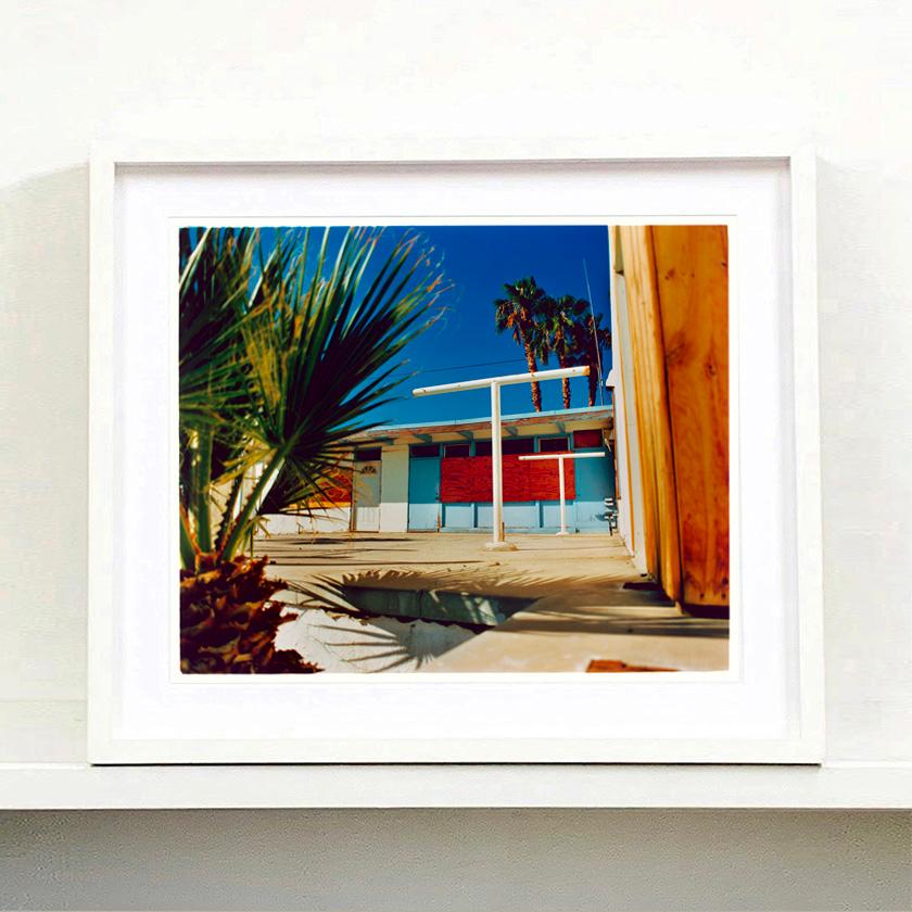 Motel Desert Shores, photographie tirée de la série Salton Sea de Richard Heeps. Cette œuvre d'art a l'allure d'un road trip en Californie du Sud, les couleurs sont si séduisantes, les palmiers créent une oasis dans le désert au milieu d'une