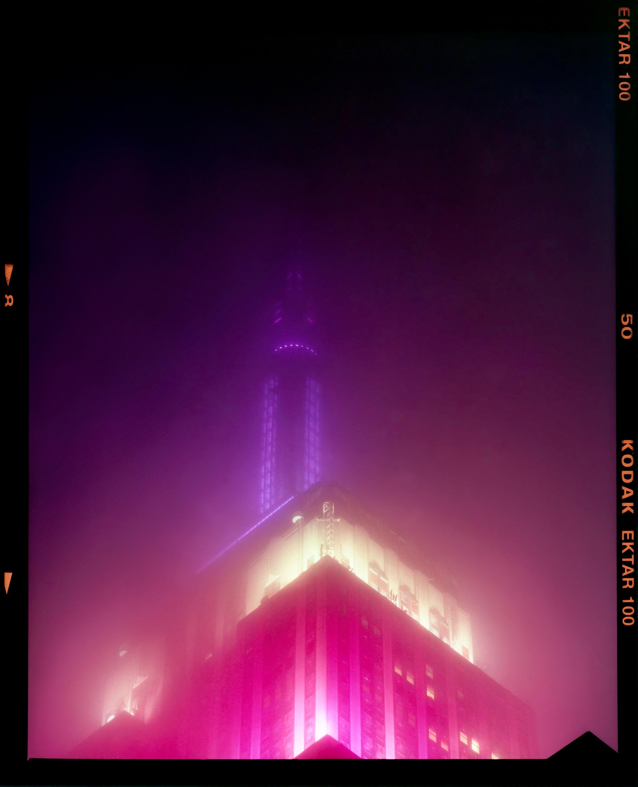 'NOMAD I (Film Rebate)', New York. Richard Heeps has photographed the iconic Empire State building in the mist. The NOMAD sequence of photographs capture the art deco architecture illuminated by changing colours, and is part of Richard's street
