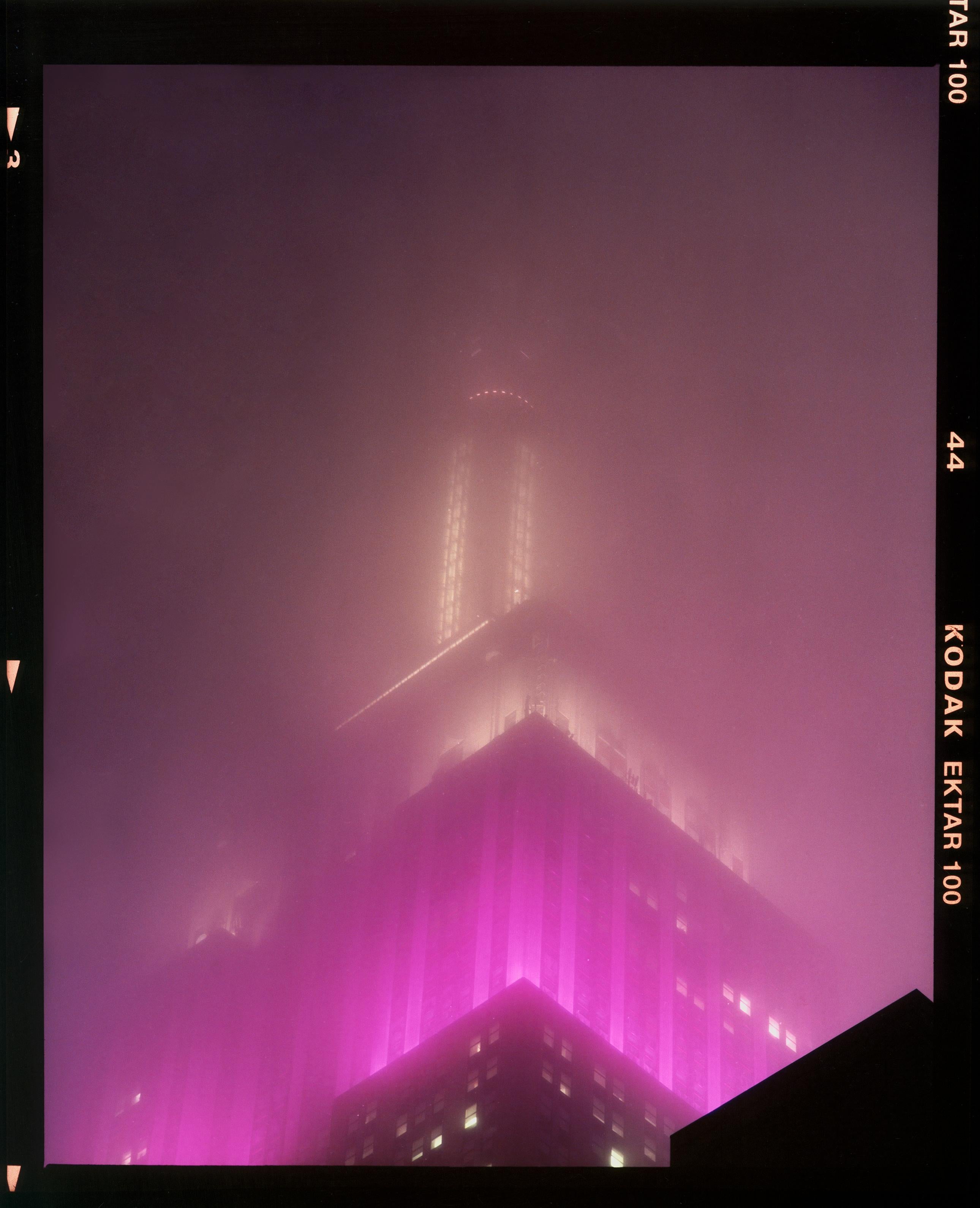 'NOMAD XI (Film Rebate)', New York. Richard Heeps has photographed the iconic Empire State building in the mist. The NOMAD sequence of photographs capture the art deco architecture illuminated by changing colours, and is part of Richard's street