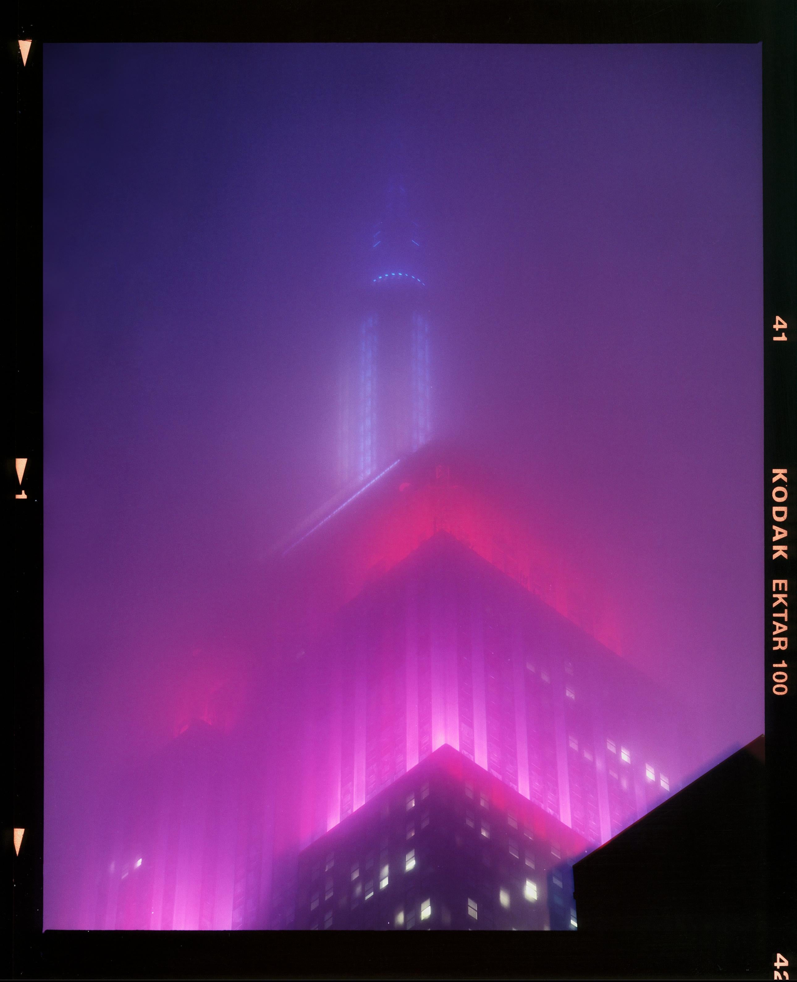 'NOMAD V (Film Rebate)', New York. Richard Heeps has photographed the iconic Empire State building in the mist. The NOMAD sequence of photographs capture the art deco architecture illuminated by changing colours, and is part of Richard's street