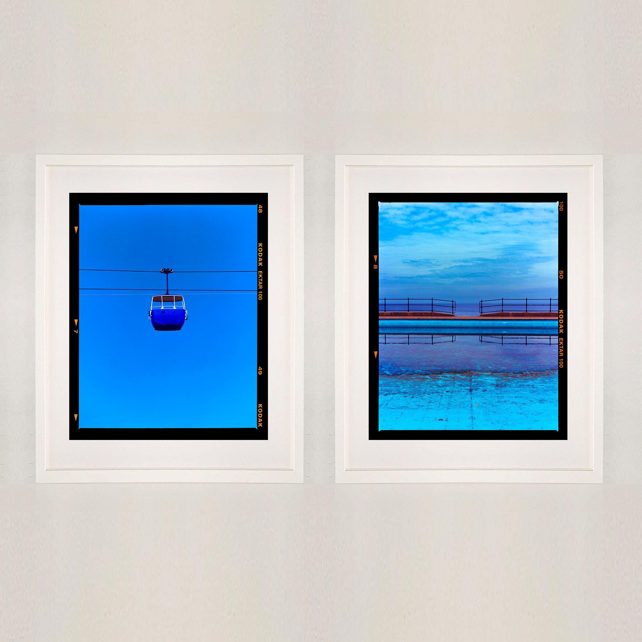 Teleférico Summit (Azul), fotografía de la serie On-Sea de Richard Heeps.

Esta obra de arte es una edición limitada de 25, impresión fotográfica brillante, montada en seco sobre aluminio, se presenta en un soporte de ventana blanco de cartón de