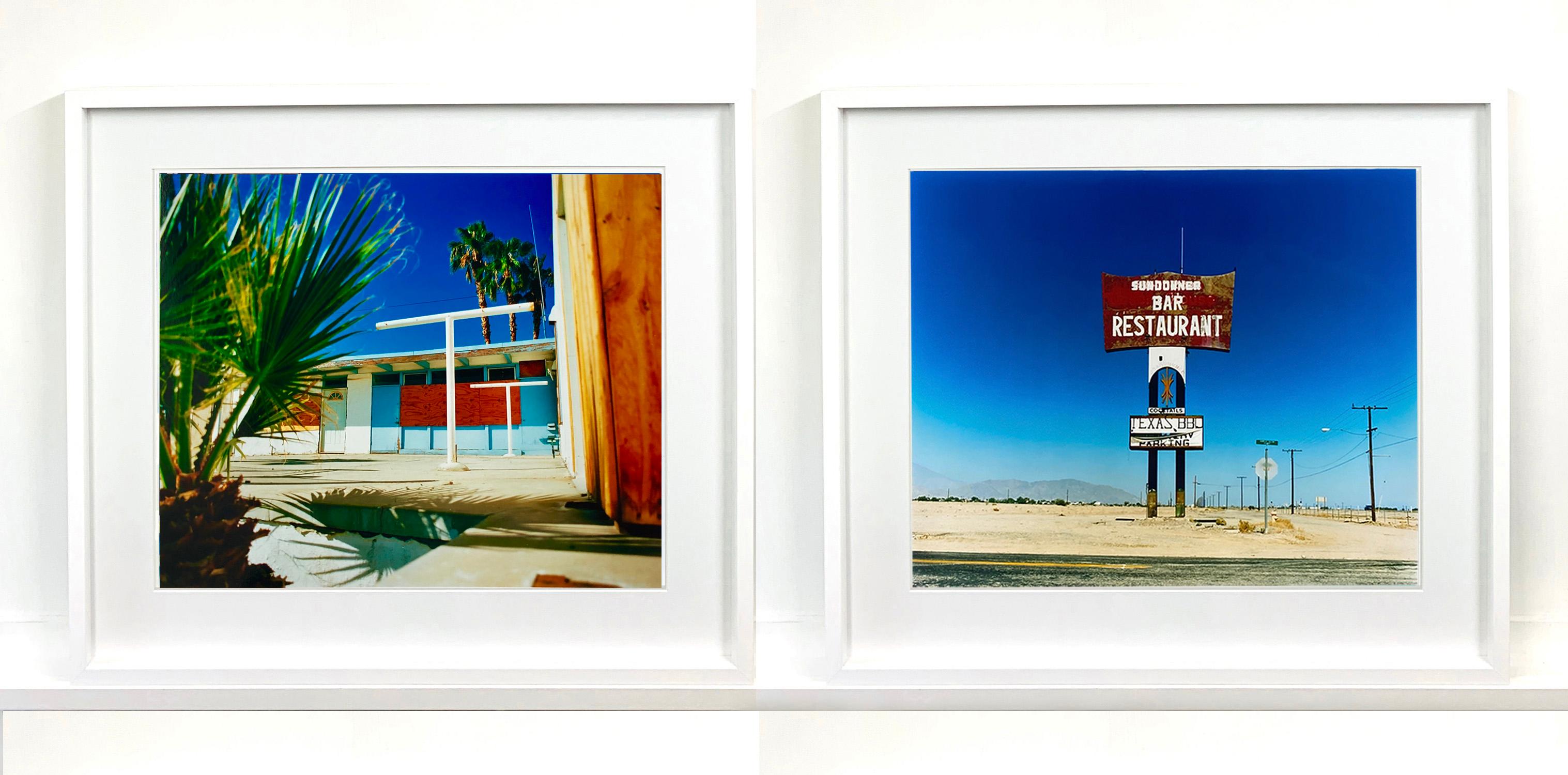 Este gran letrero gigante aislado al borde de la carretera, sobre un vasto cielo azul, es un vestigio del Bar y Restaurante Sundowner del Motel, que desgraciadamente ya no existe. Esta fotografía, que forma parte de la Serie del Mar Salton de