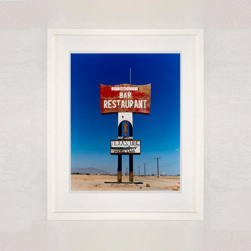 This giant isolated roadside sign set against a vast blue sky is a remnant of 'The Sundowner Bar and Restaurant' of the motel which is sadly more. This photograph, part of Richard Heeps' 'Salton Sea' series captures the landscape of the western side
