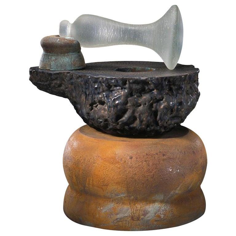 Contemporary American ceramic artist Richard Hirsch's Mortar and Glass Pestle Sculpture #10 was assembled in 2004. It's wheel thrown and hand built clay with black glaze, raku patinas and hot blown glass. The following is an excerpt from the book