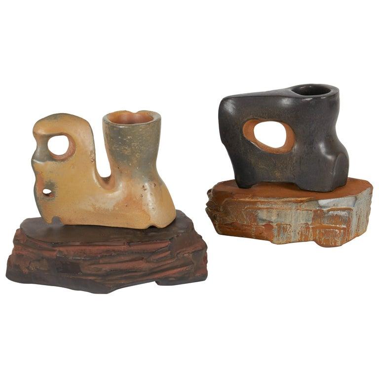 Les tasses Primal Cups with Stands #5 et #12 de l'artiste américain contemporain Richard Hirsch sont cuites au raku, fabriquées et sculptées à la main. Hirsch crée des sculptures en céramique qui explorent la spiritualité et les rituels inhérents