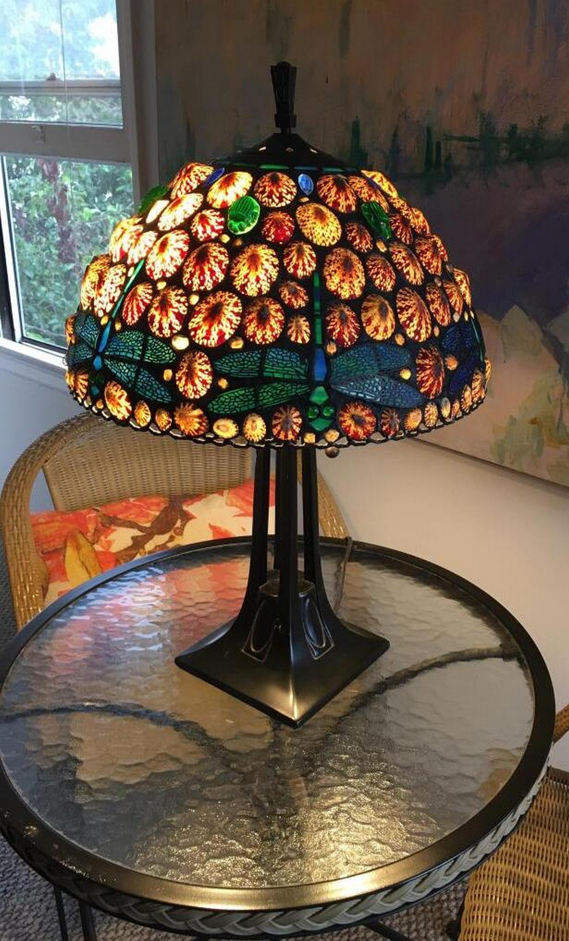 Fascinating lamp made of shells and glass. it is stamped, dated, signed, and numbered.
This lamp was hand-made using the same techniques developed by Louis Tiffany in the early 1900s.
Hoosin combines shells and transparent colorful glass. The