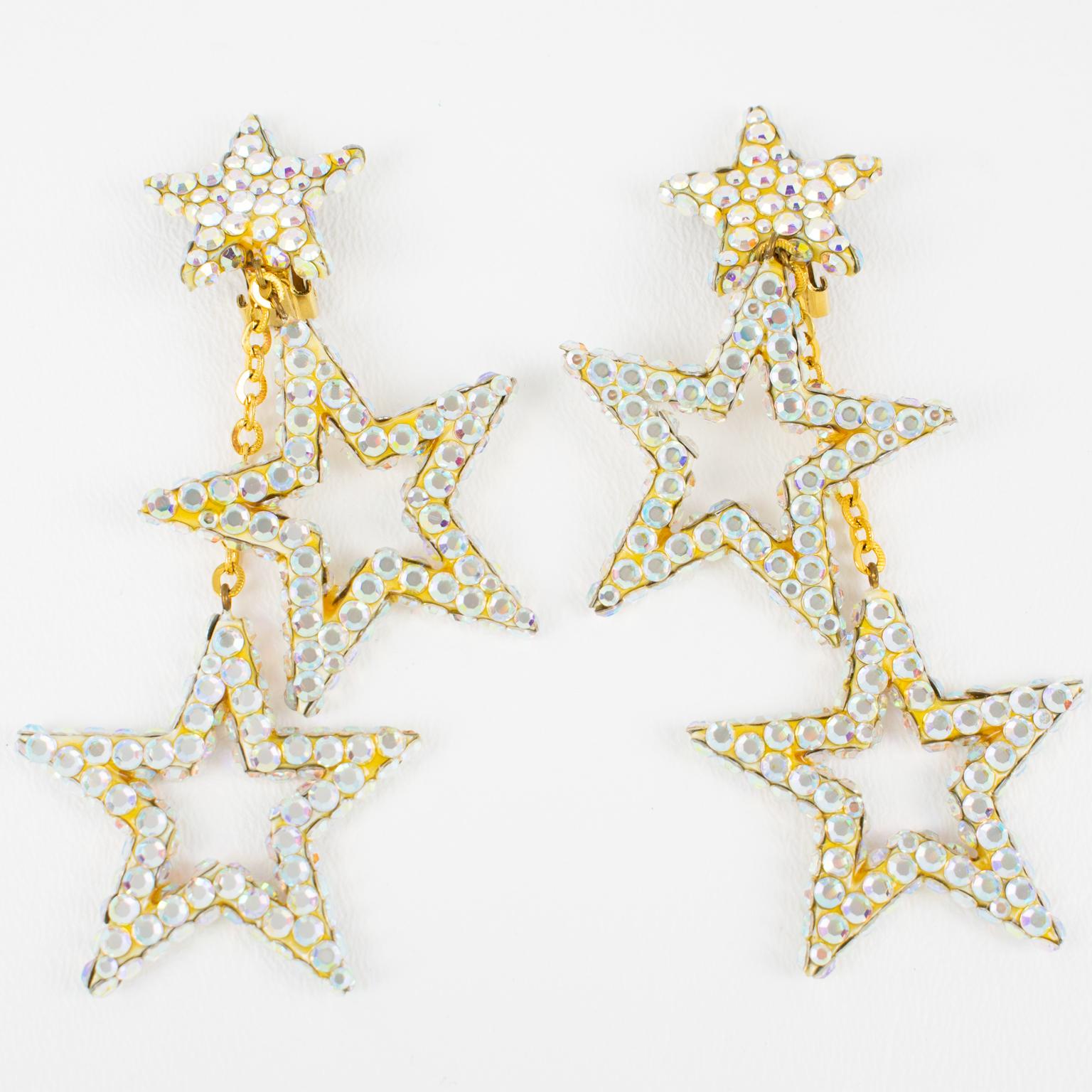 Richard Kerr designed these gorgeous chandelier clip-on earrings in the 1980s. They are made of his signature pave rhinestones. The pieces boast a cascading shape with two star-shaped dangling charms, all covered with Aurora Borealis AB crystal