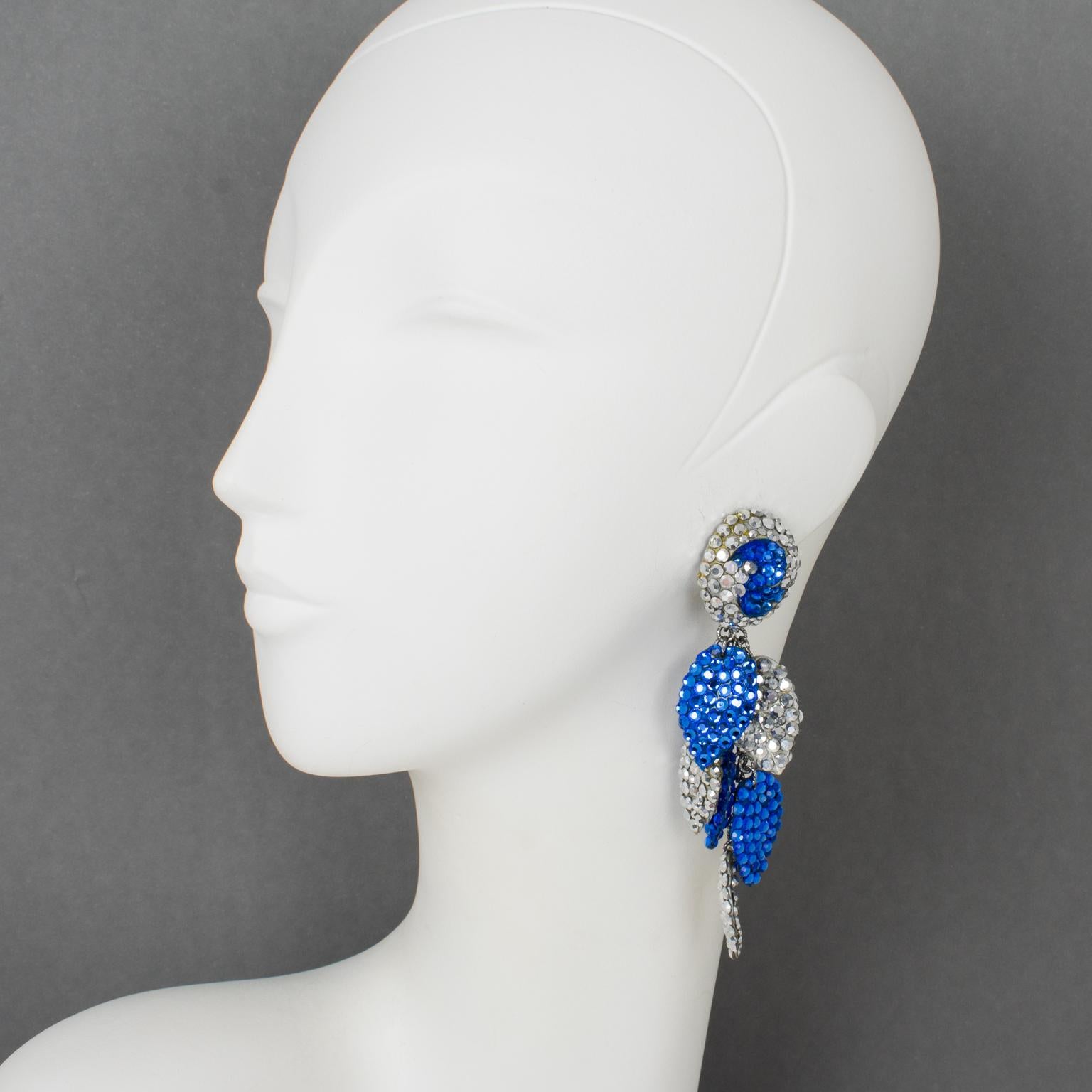 Richard Kerr designed these stylish cascading clip-on earrings in the 1980s. They are made of his signature pave rhinestones. They feature an extra-long dangling shape with multi-chain and leaves-shaped elements attached to them, all covered with