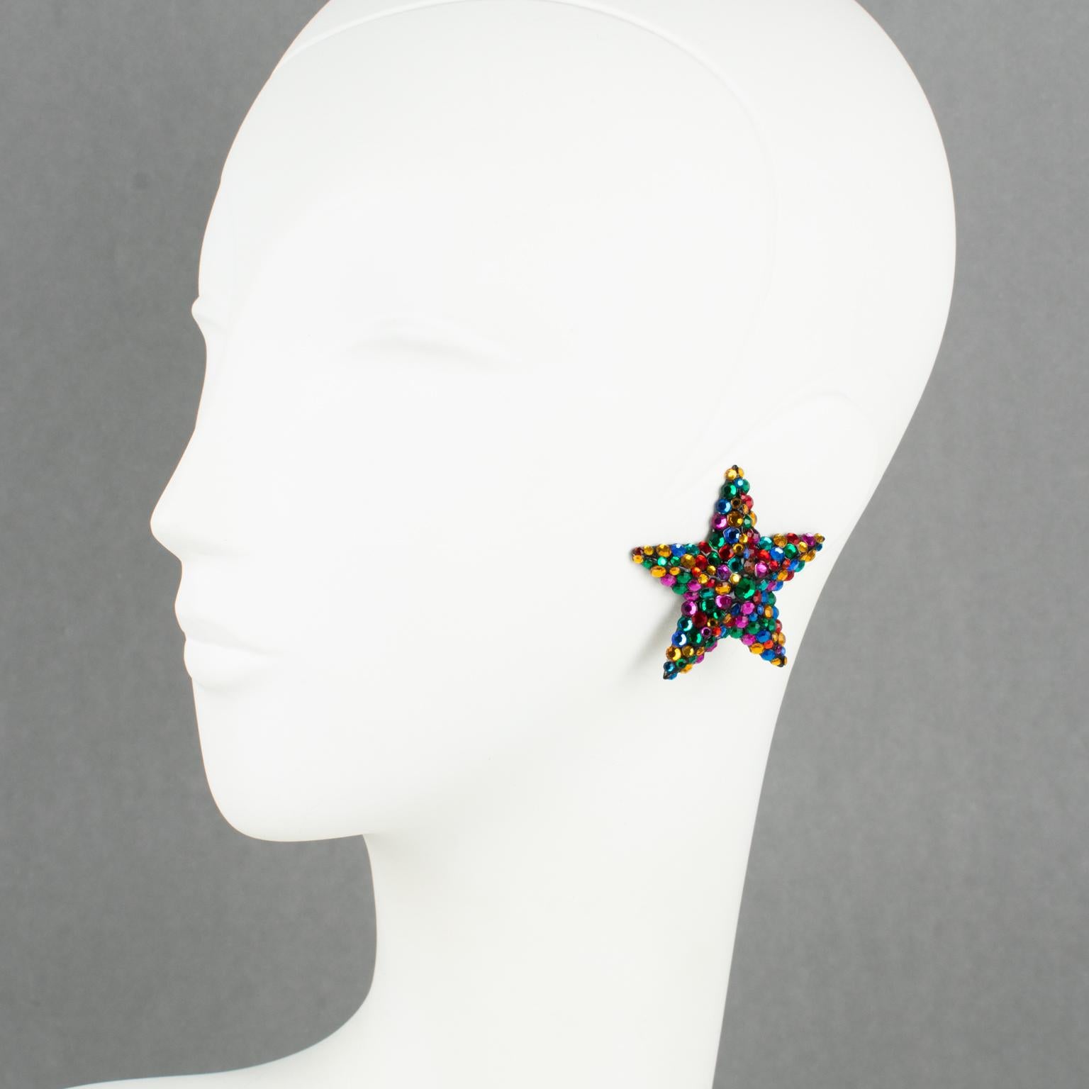 Richard Kerr crafted these elegant clip-on earrings in the 1980s. They are made of his signature pave rhinestones. 
They feature an oversized star shape covered with multicolor crystal rhinestones. The earrings are set on a black resin background