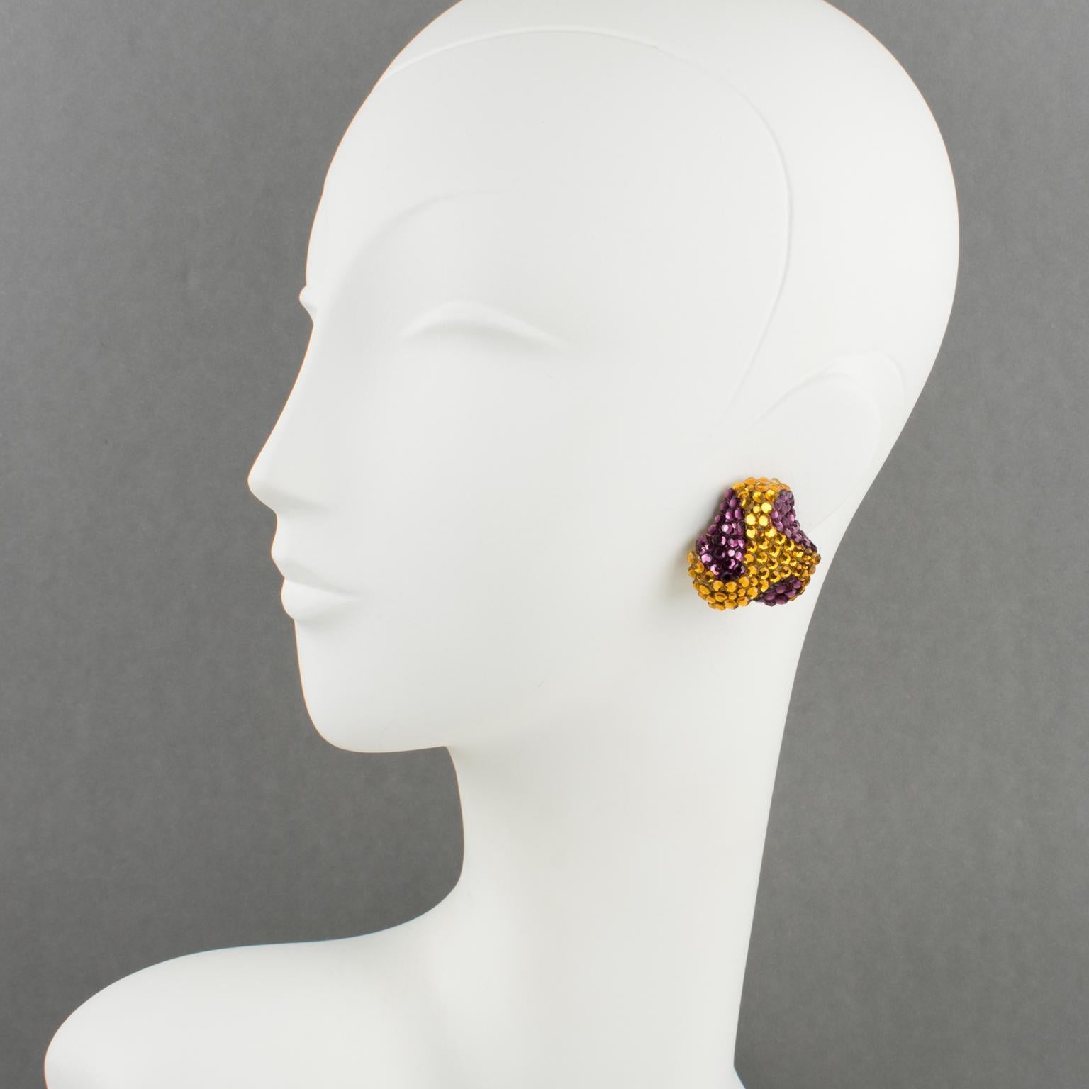 Richard Kerr designed those lovely statement clip-on earrings in the 1980s. 
The brand signature rhinestone paved design features a dimensional triskelion shape, all covered in colored crystal rhinestones over a cream resin background framing.
Vivid