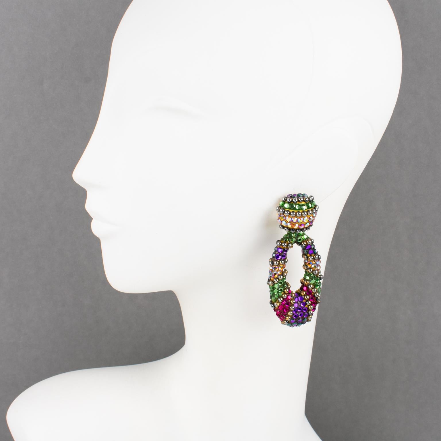 These fabulous statement clip-on earrings were designed by Richard Kerr in the 1980s. They are made up of his signature pave crystal rhinestones. Featuring a dangle geometric shape all covered with multicolor rhinestones. Assorted colors of purple,