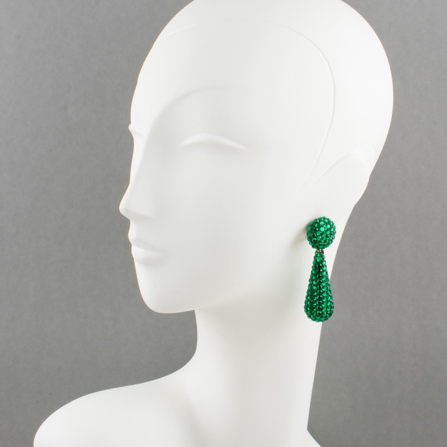 Gorgeous statement clip-on earrings designed by Richard Kerr in the 1980s. They are made up of his signature pave rhinestones. Featuring dangling long teardrop shape all covered with colorful crystal rhinestones on green resin background frame.