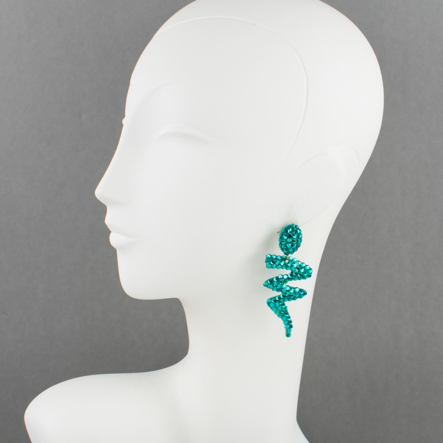 Richard Kerr designed these elegant pierced earrings in the 1980s. They are made up of his signature paved crystal rhinestones. They feature a long dangle zig-zag turquoise resin shape, all covered with turquoise color crystal rhinestones. There is