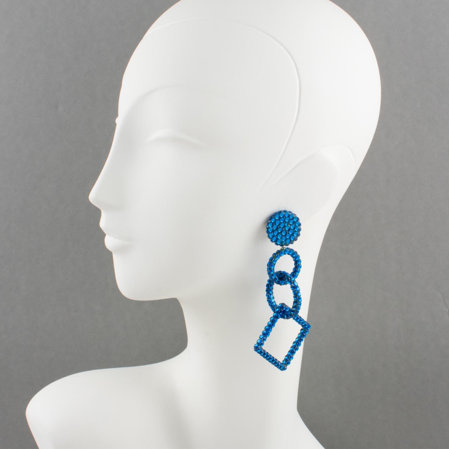 Stunning statement chandelier clip-on earrings designed by Richard Kerr in the 1980s. They are made up of his signature pave rhinestones. Featuring oversized shape design with geometric-shaped dangling elements all covered with cobalt blue crystal