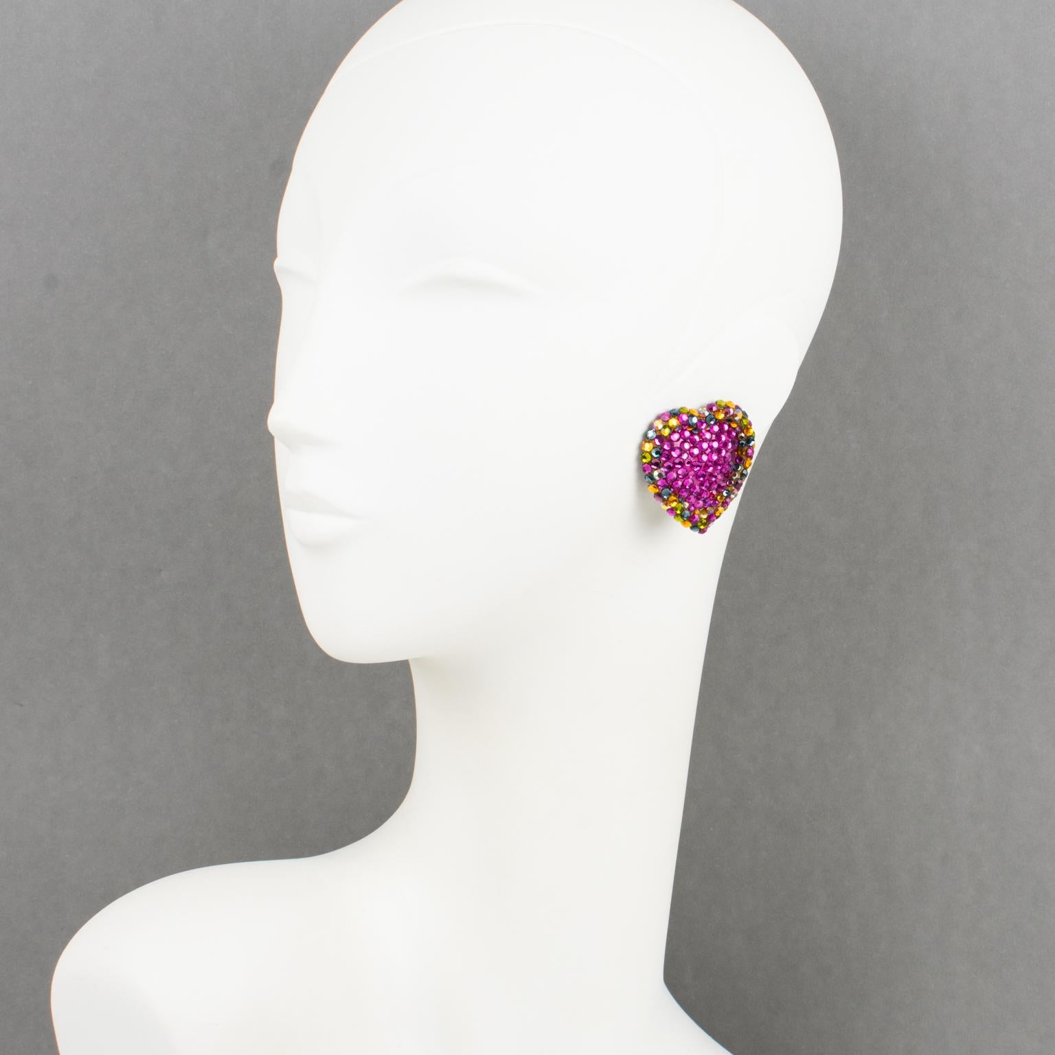 Richard Kerr designed these gorgeous clip-on earrings in the 1980s. They are made of his signature pave rhinestones. 
They feature an oversized heart shape covered with multicolor crystal rhinestones. The earrings are set on a black resin background