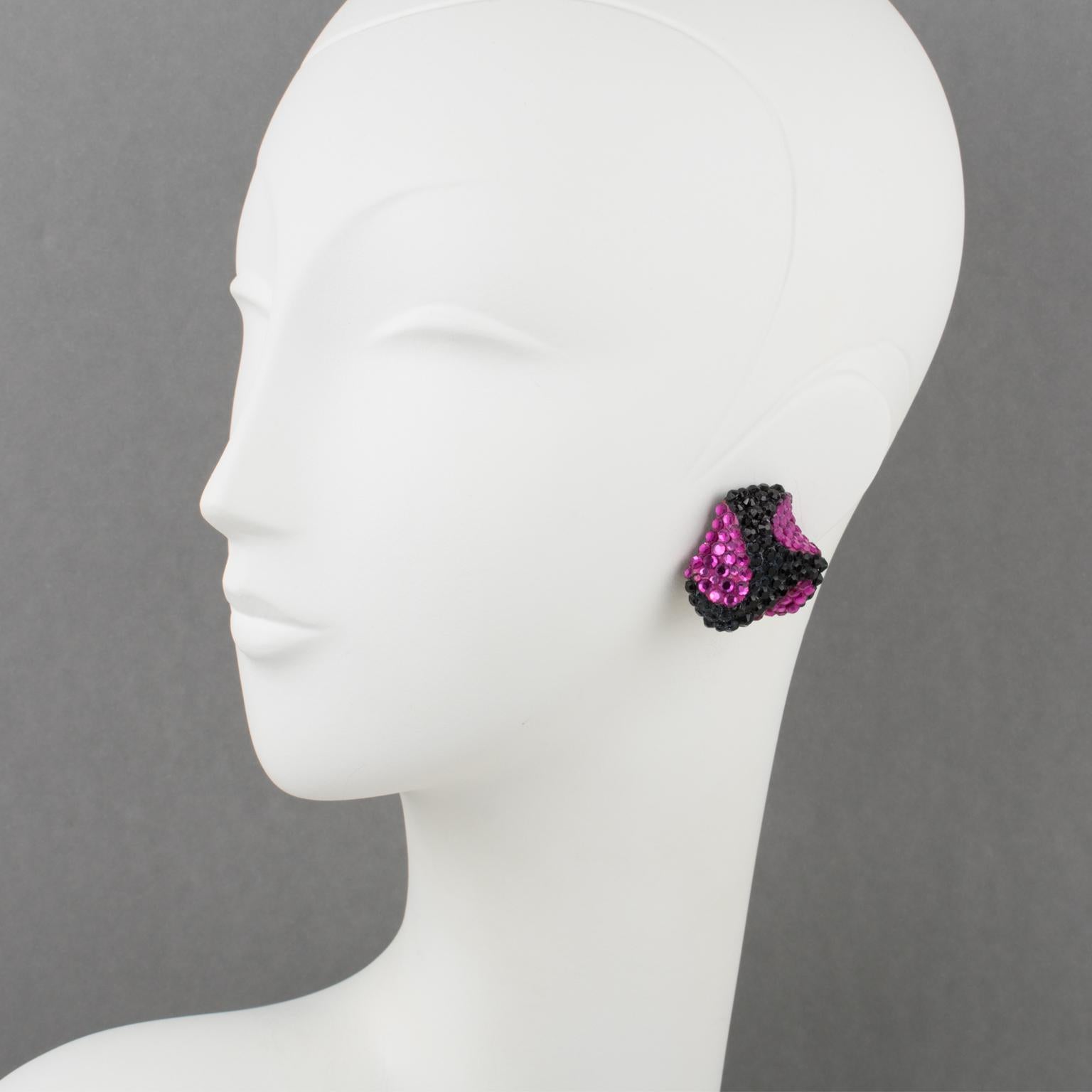 Richard Kerr a conçu ces superbes boucles d'oreilles à clip dans les années 1980. Elles sont composées des strass pavés qui ont fait sa renommée et présentent un triskelion de forme dimensionnelle recouvert de strass de cristal colorés sur un fond